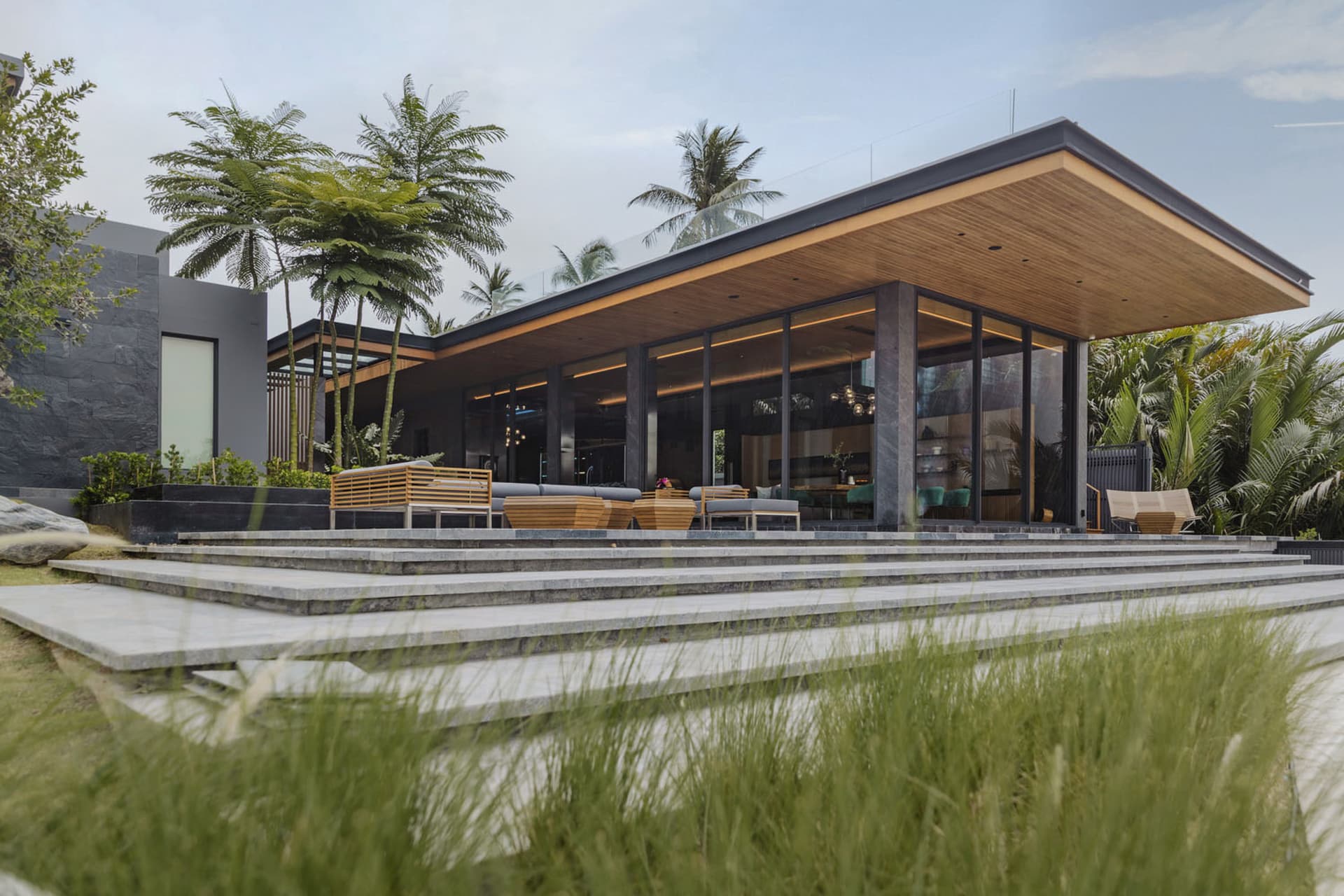Modern residential architecture featuring a wooden roof and outdoor seating area.