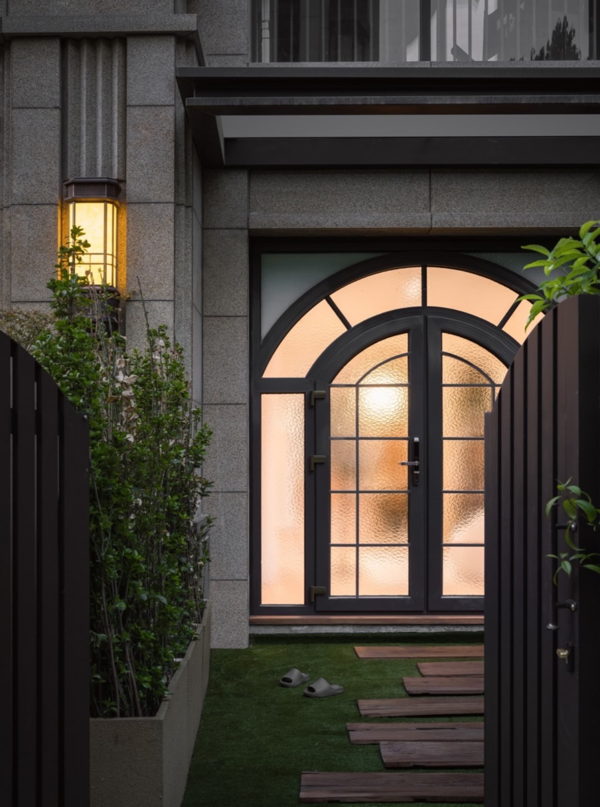 A modern residential entrance featuring glass and concrete materials.