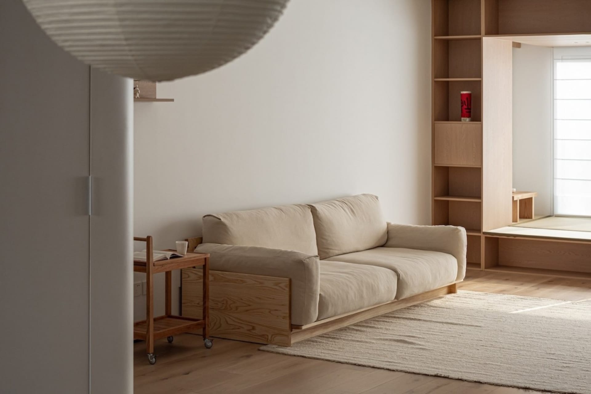 A minimalist living room with a sofa and a wooden cart.