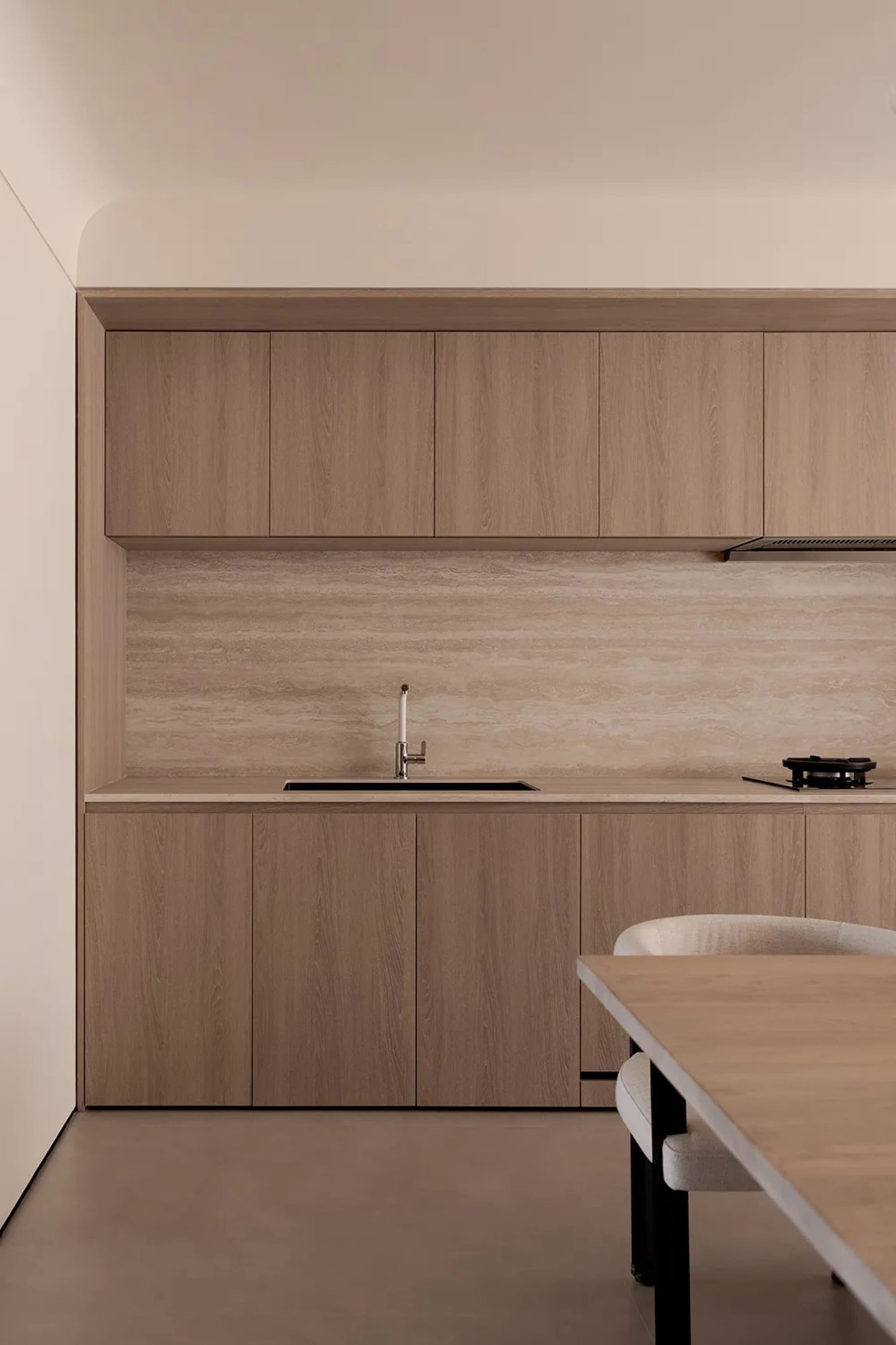 Modern, minimalist commercial kitchen with wooden cabinets and countertop.