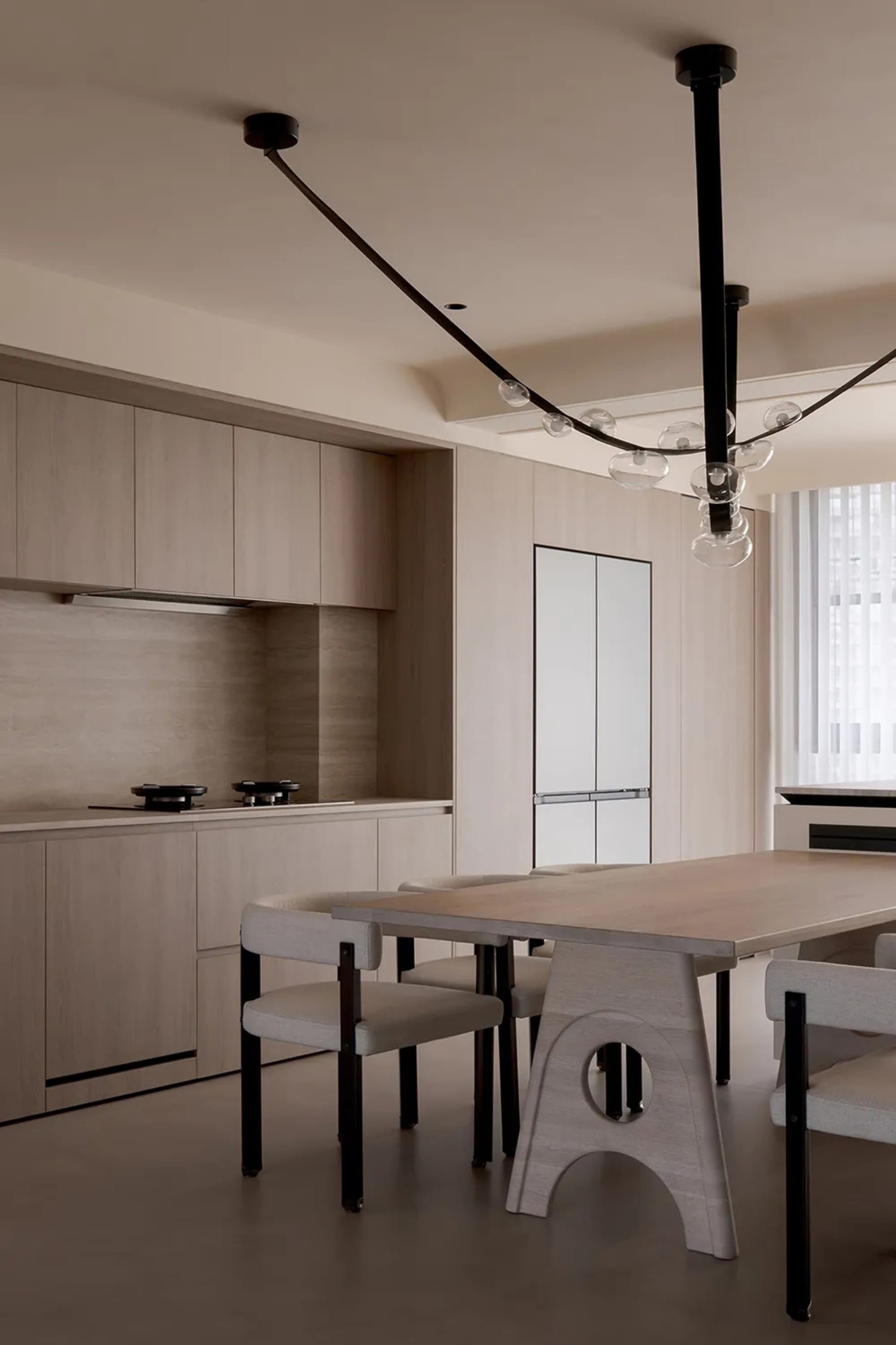 Modern residential kitchen with wood cabinetry, glass backsplash, and stainless steel appliances.