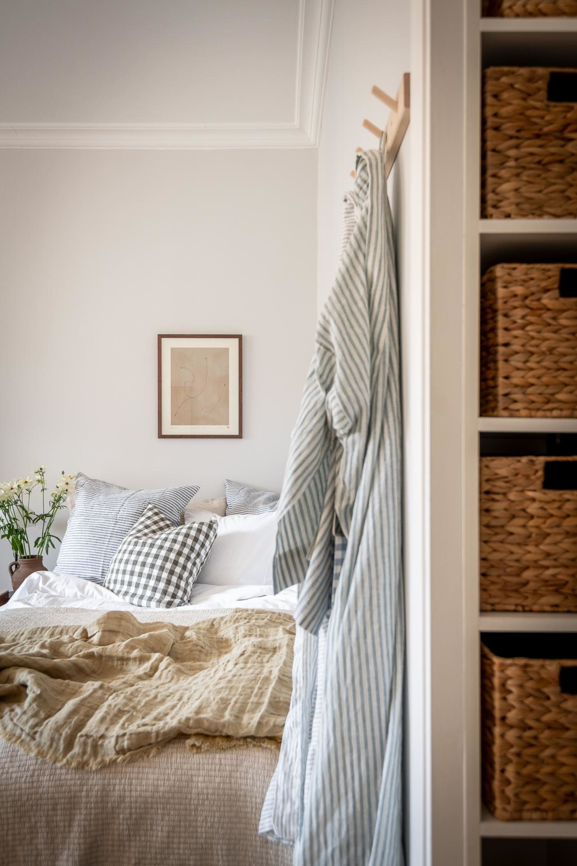 A minimalist bedroom with textiles, woven baskets, and wooden elements.