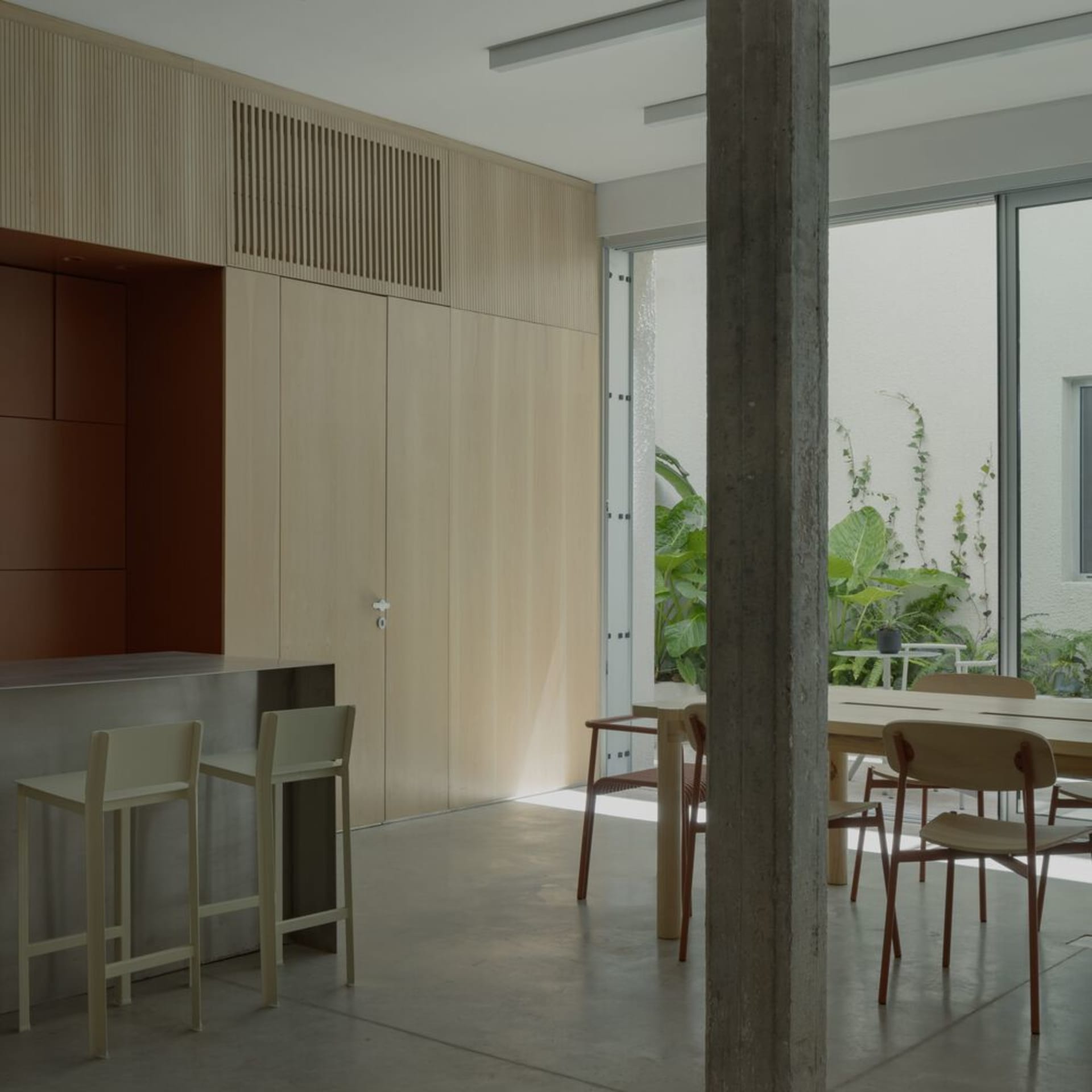 Minimalist dining room featuring modern furniture, concrete floor, and natural wood accents.