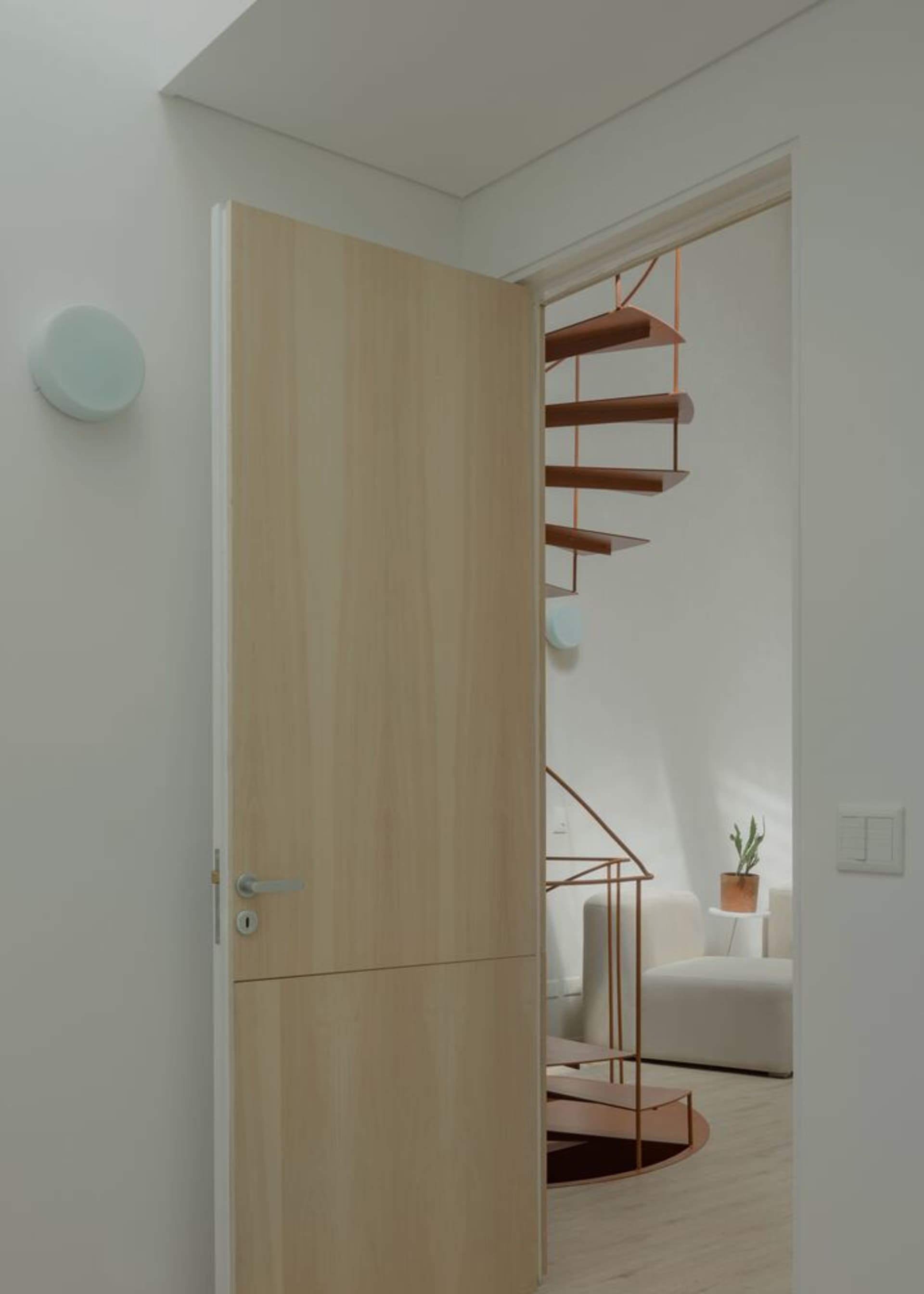 Modern interior with floating staircase, white stone flooring, and minimalist decor.