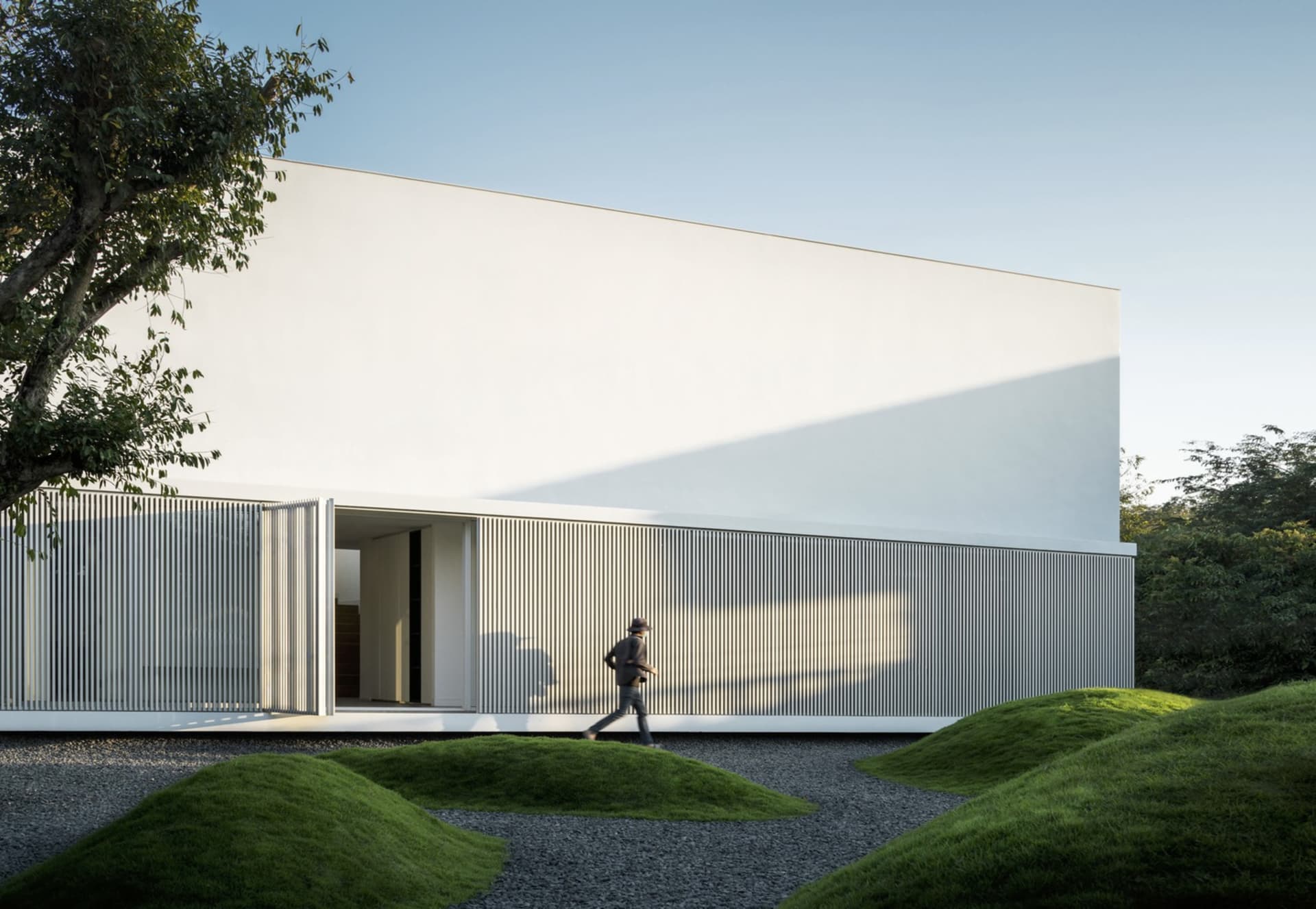 A modern minimalist residential building with a white painted concrete exterior.