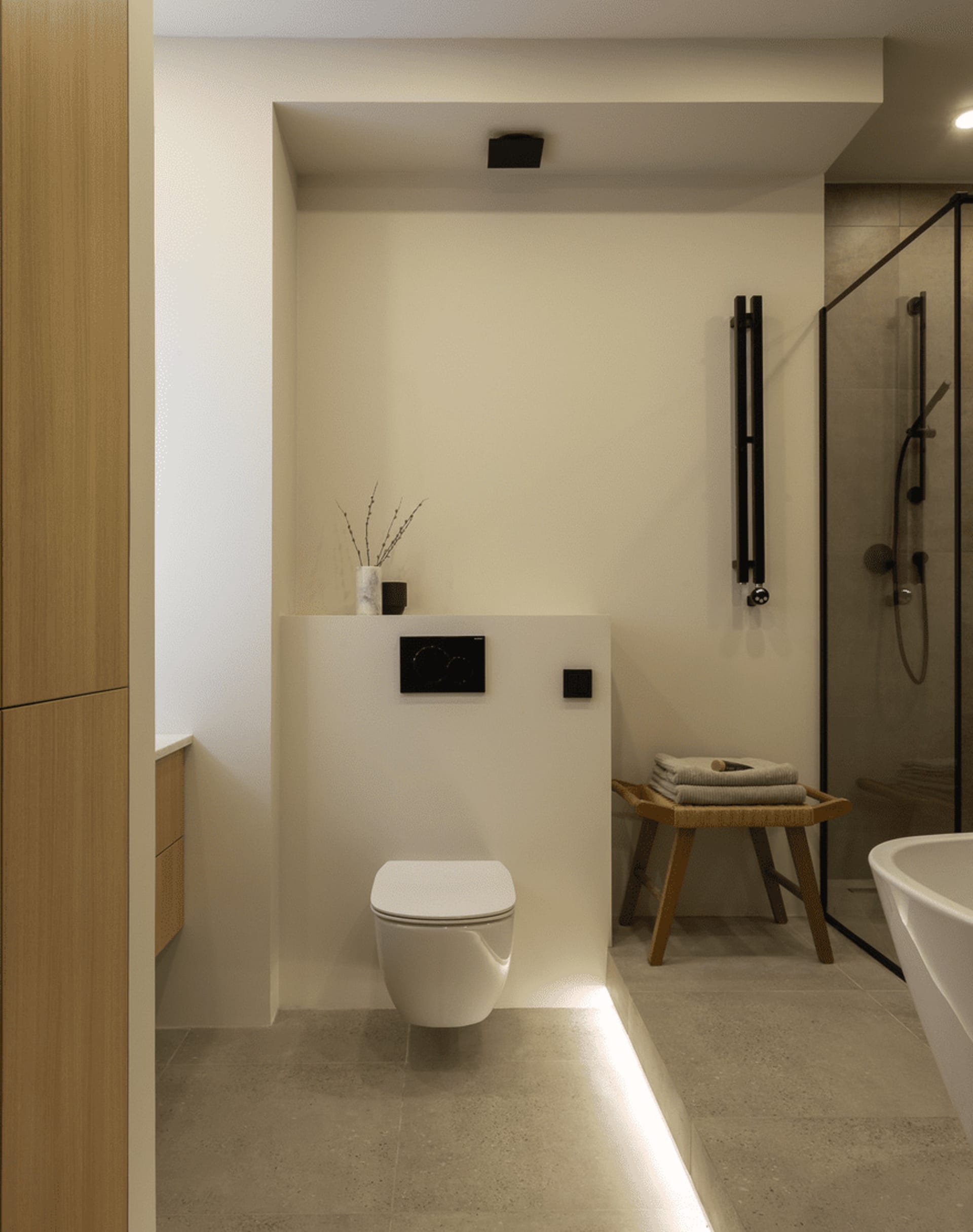 Modern minimalist bathroom with tiled walls, wooden accents, and metal fixtures