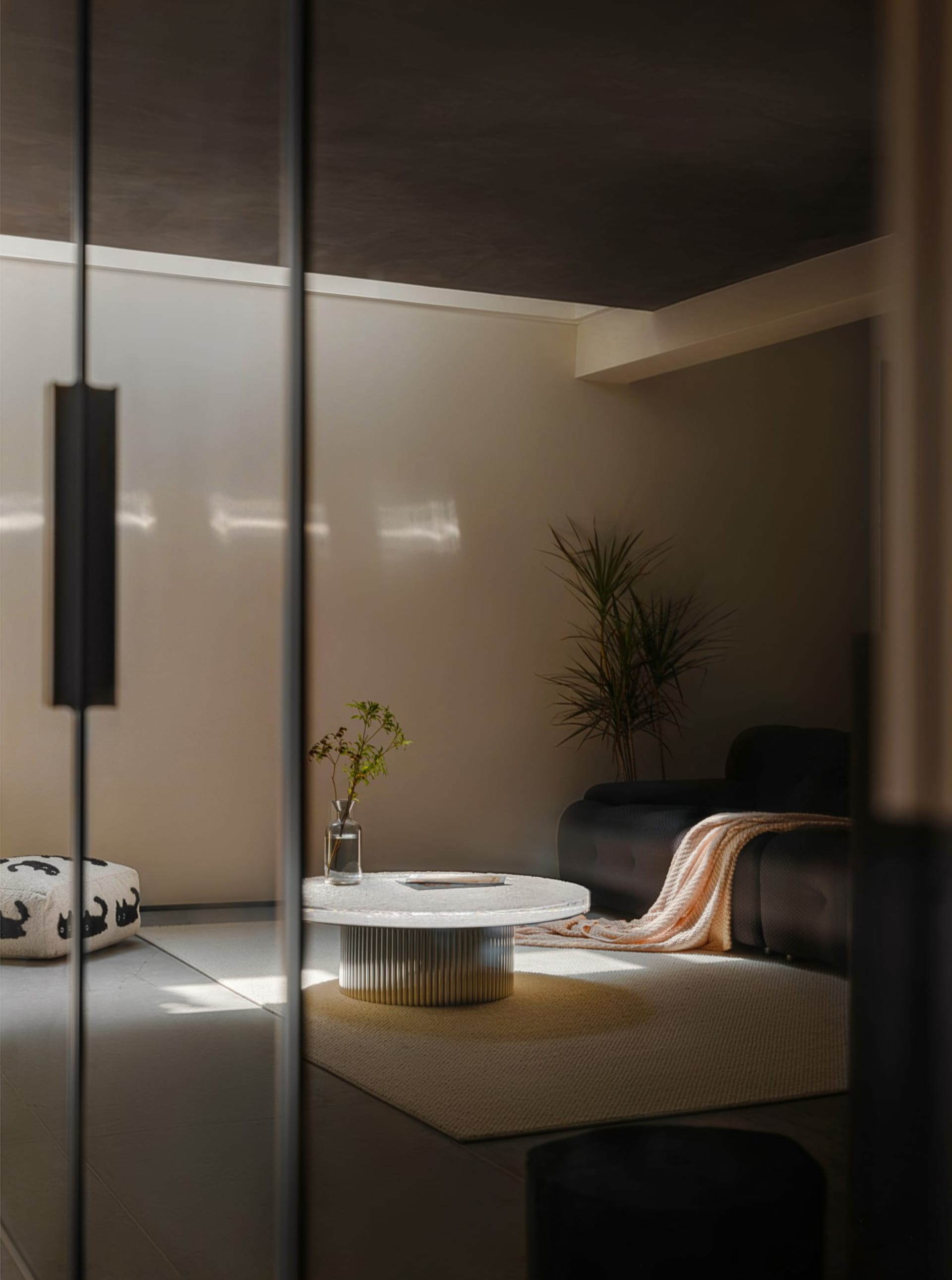 Modern minimalist living room featuring metal and glass elements.