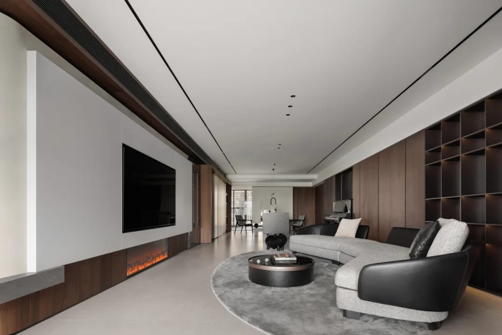 A modern living room with concrete flooring, minimalist design, and a large sectional sofa.