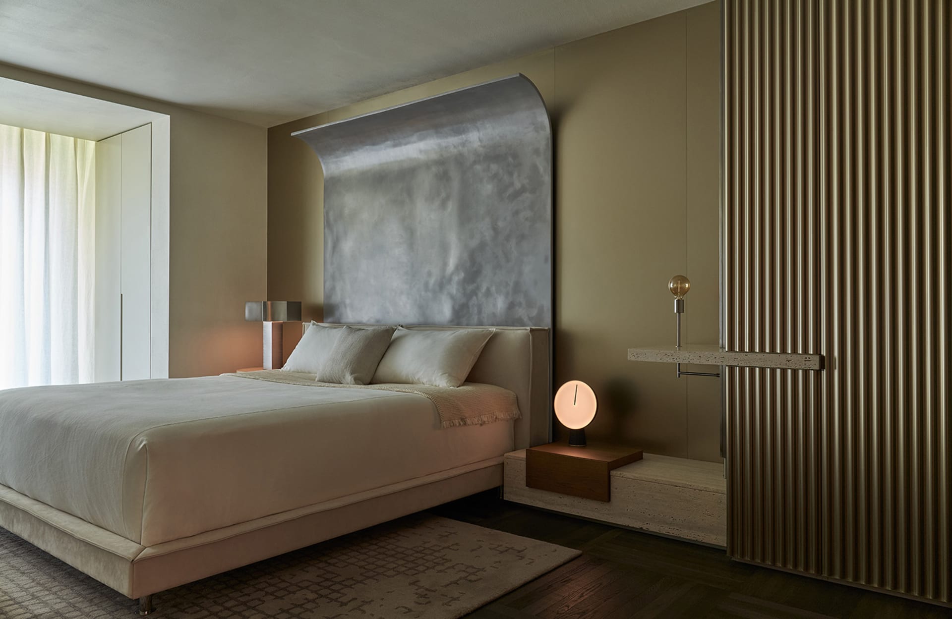 A modern bedroom with a metallic wall feature and a cozy bed setup.