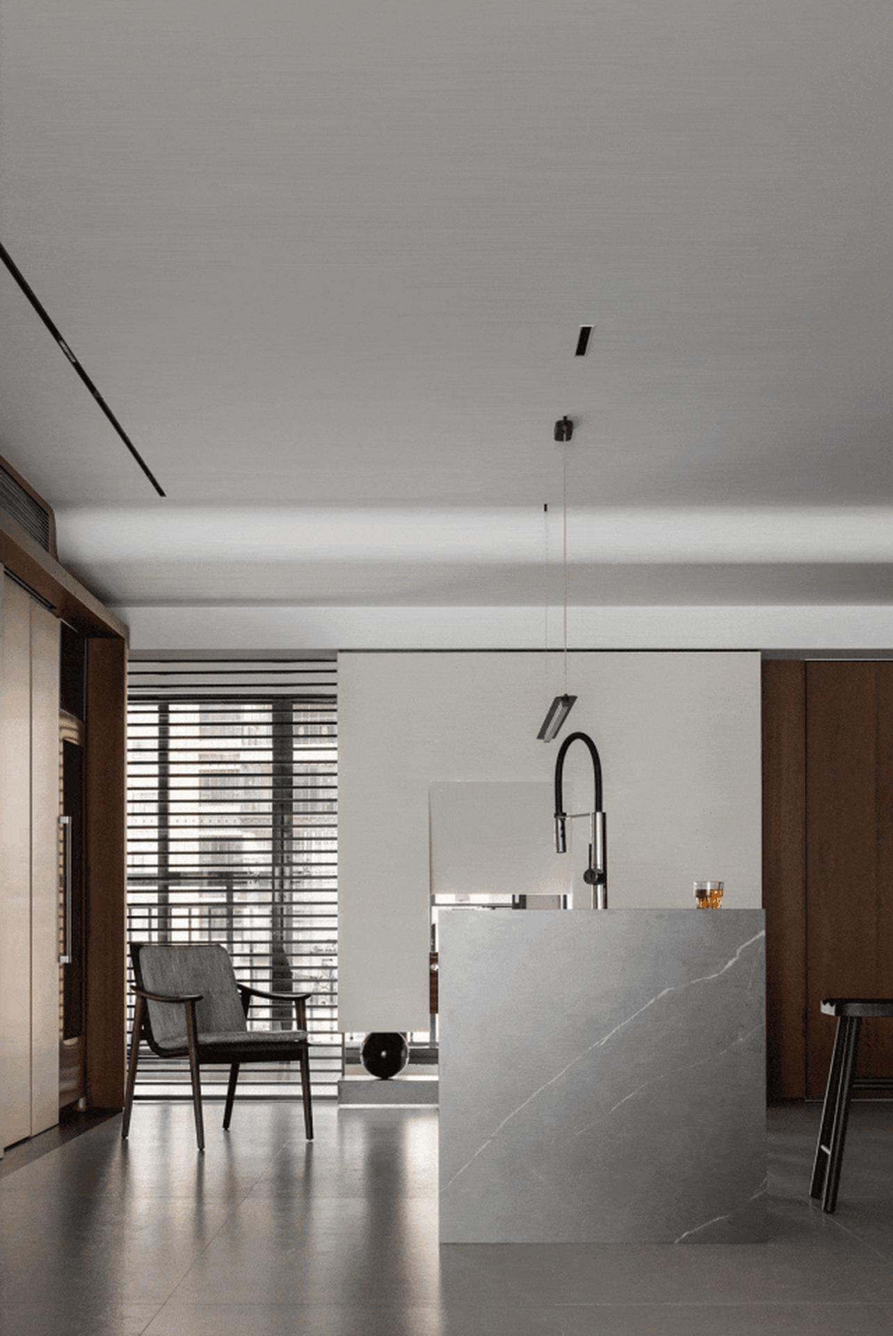 Contemporary kitchen with marble countertop, minimalist design, and industrial lighting.