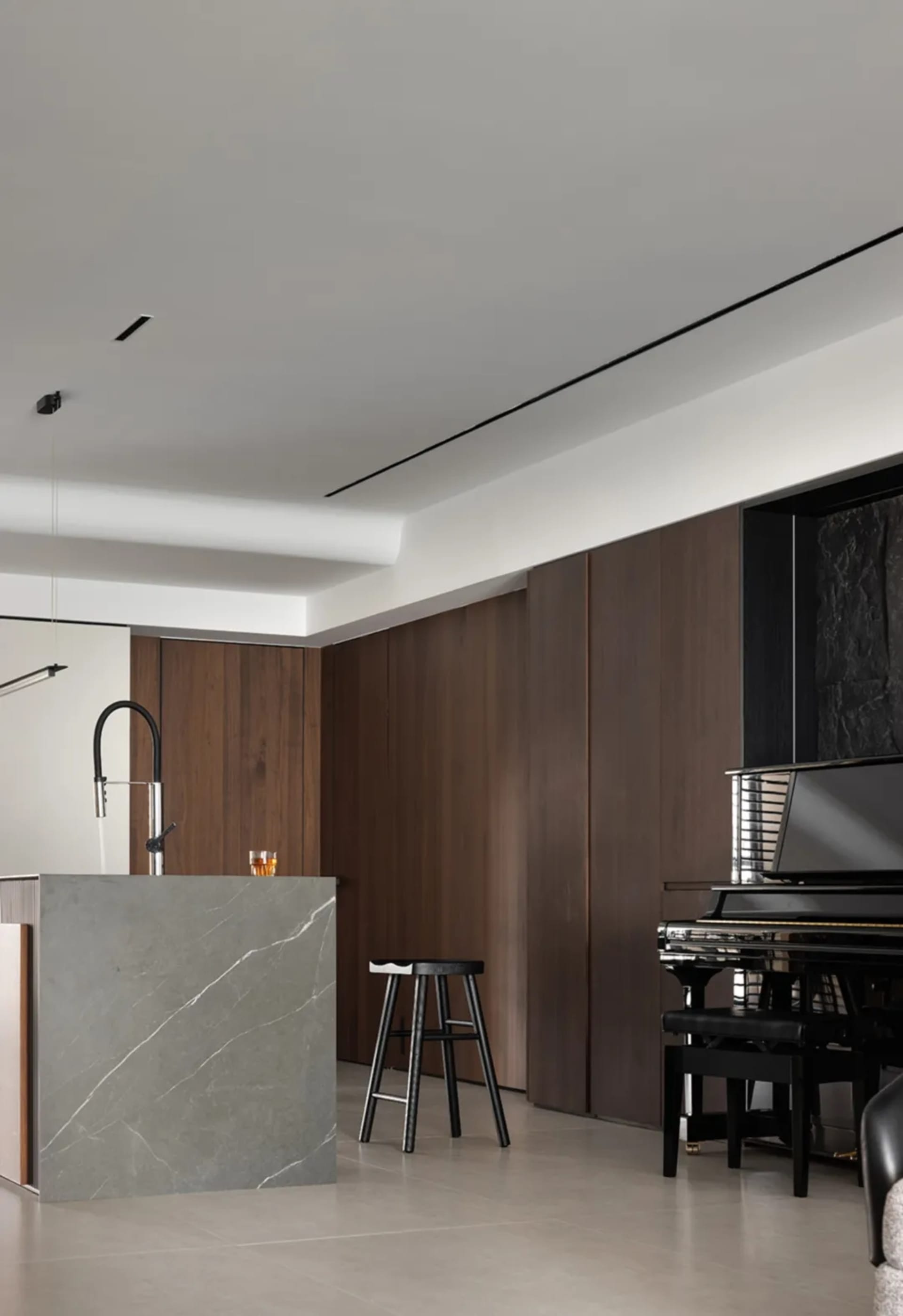 A modern living room featuring wooden panels and marble accents.