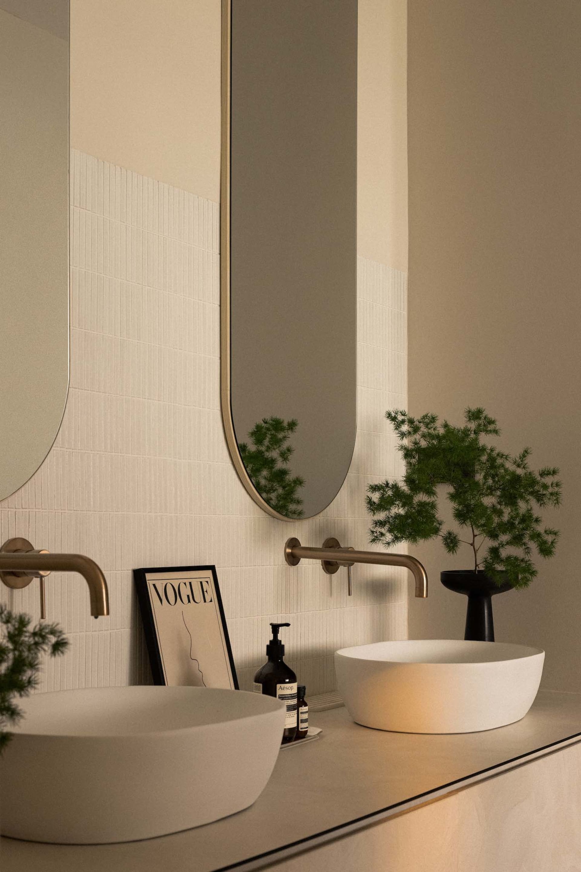 Modern bathroom featuring a white concrete sink and white textured tiles on the wall.