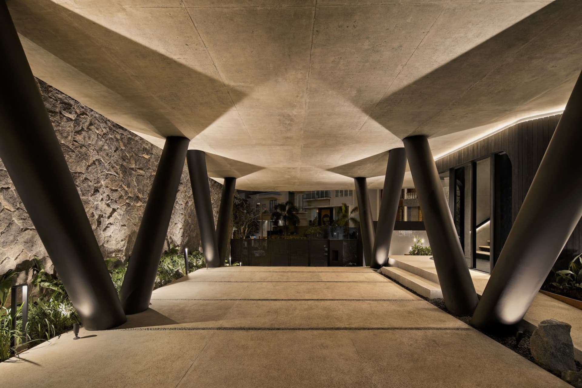 A modern entrance featuring a concrete structure with large pillars.