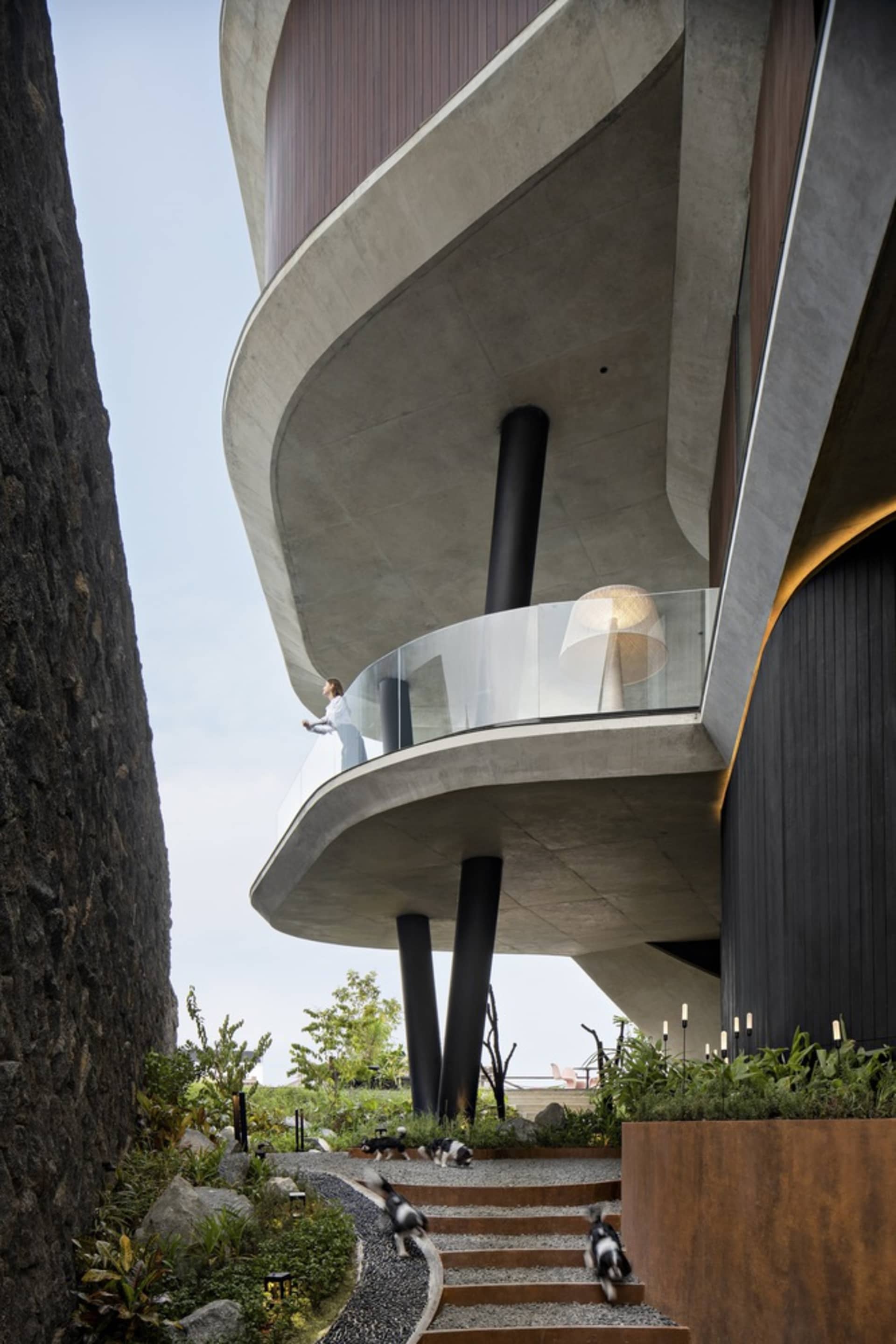 Modern residential exterior featuring concrete and glass materials.