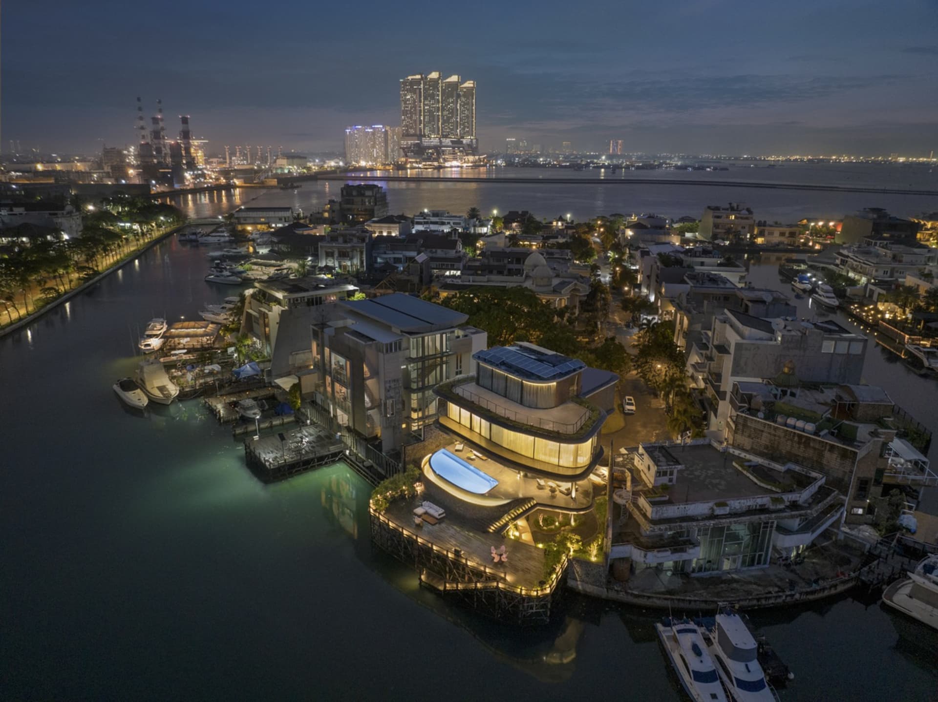 Aerial view of luxury waterfront residences featuring modern architectural elements such as glass, concrete, and steel.