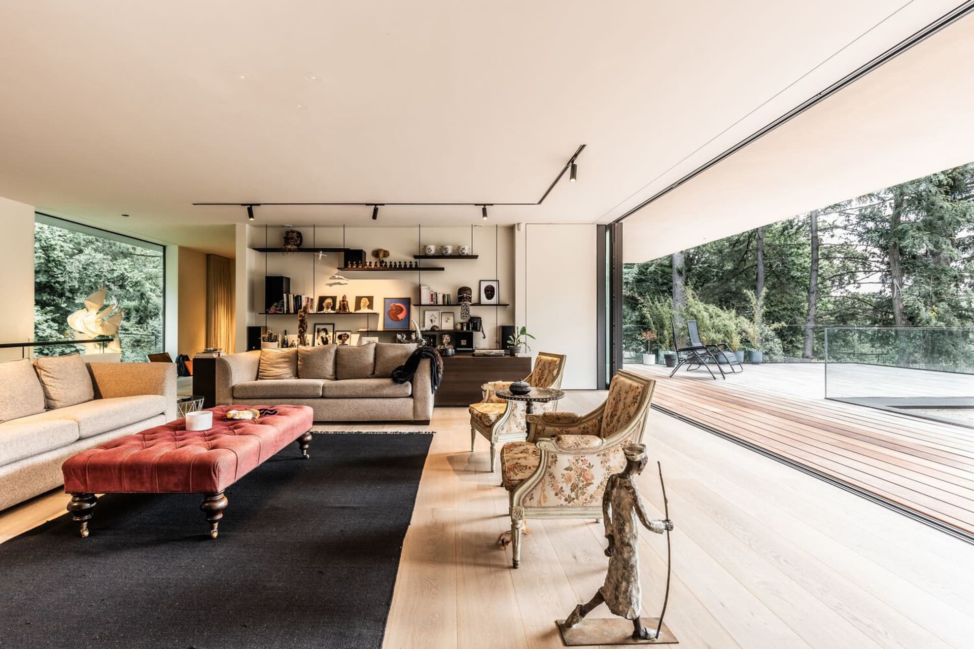 A modern living room with wooden furniture, large windows, and a comfortable seating area.