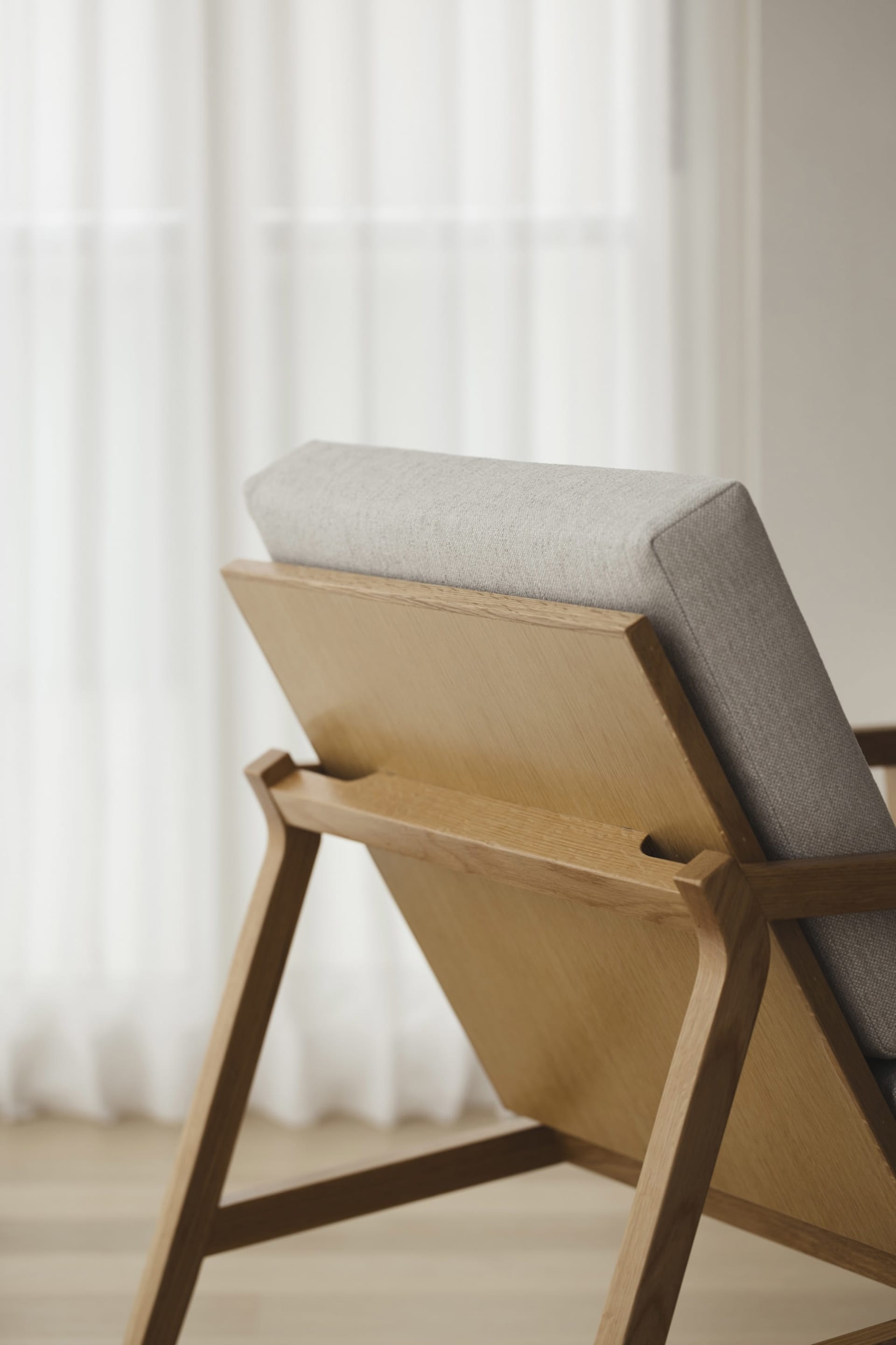 A modern oak chair with upholstered seat and backrest, featuring clean lines and a simple design.
