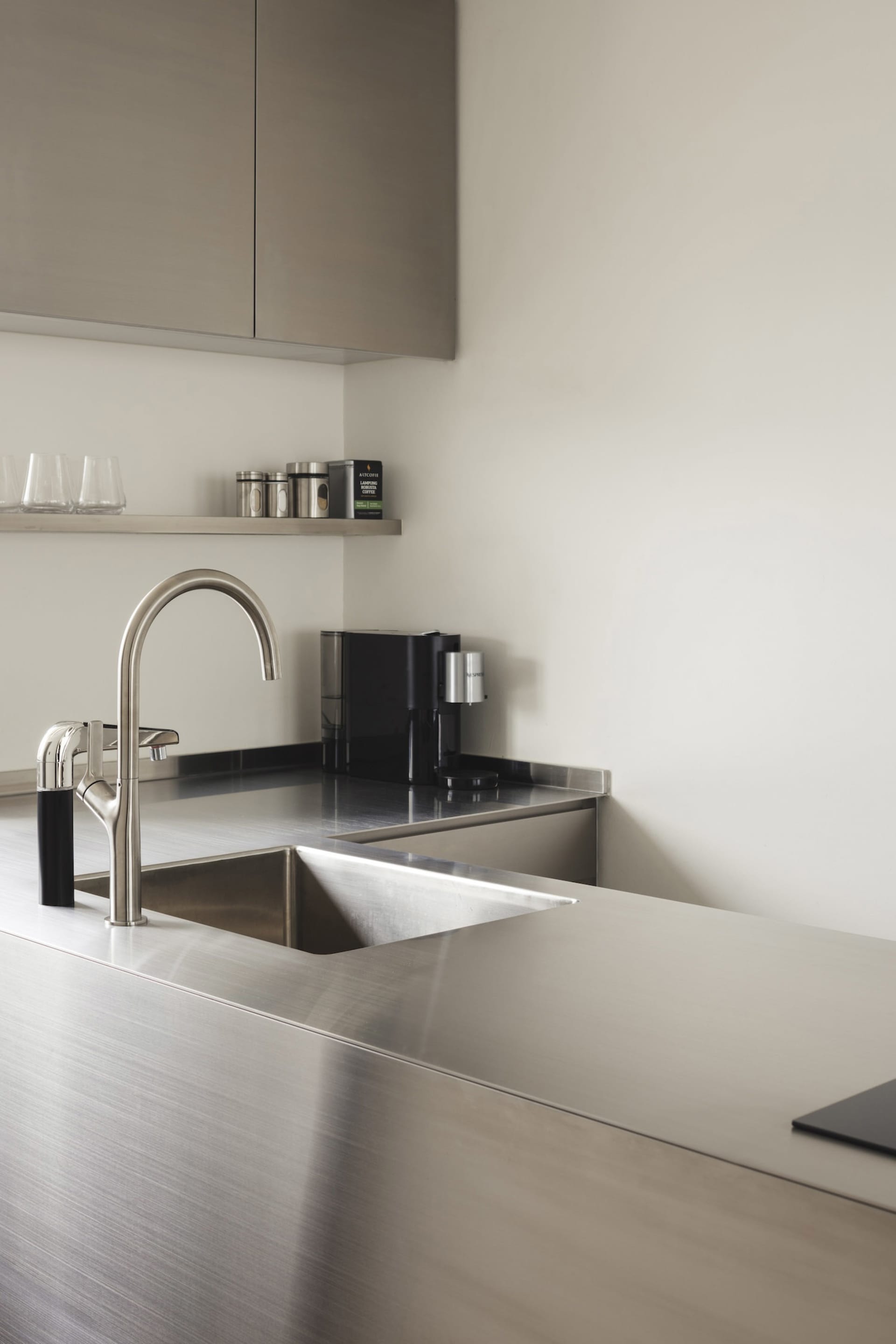 Minimalist modern kitchen with metallic stainless-steel surfaces, sleek design, and contemporary fixtures.