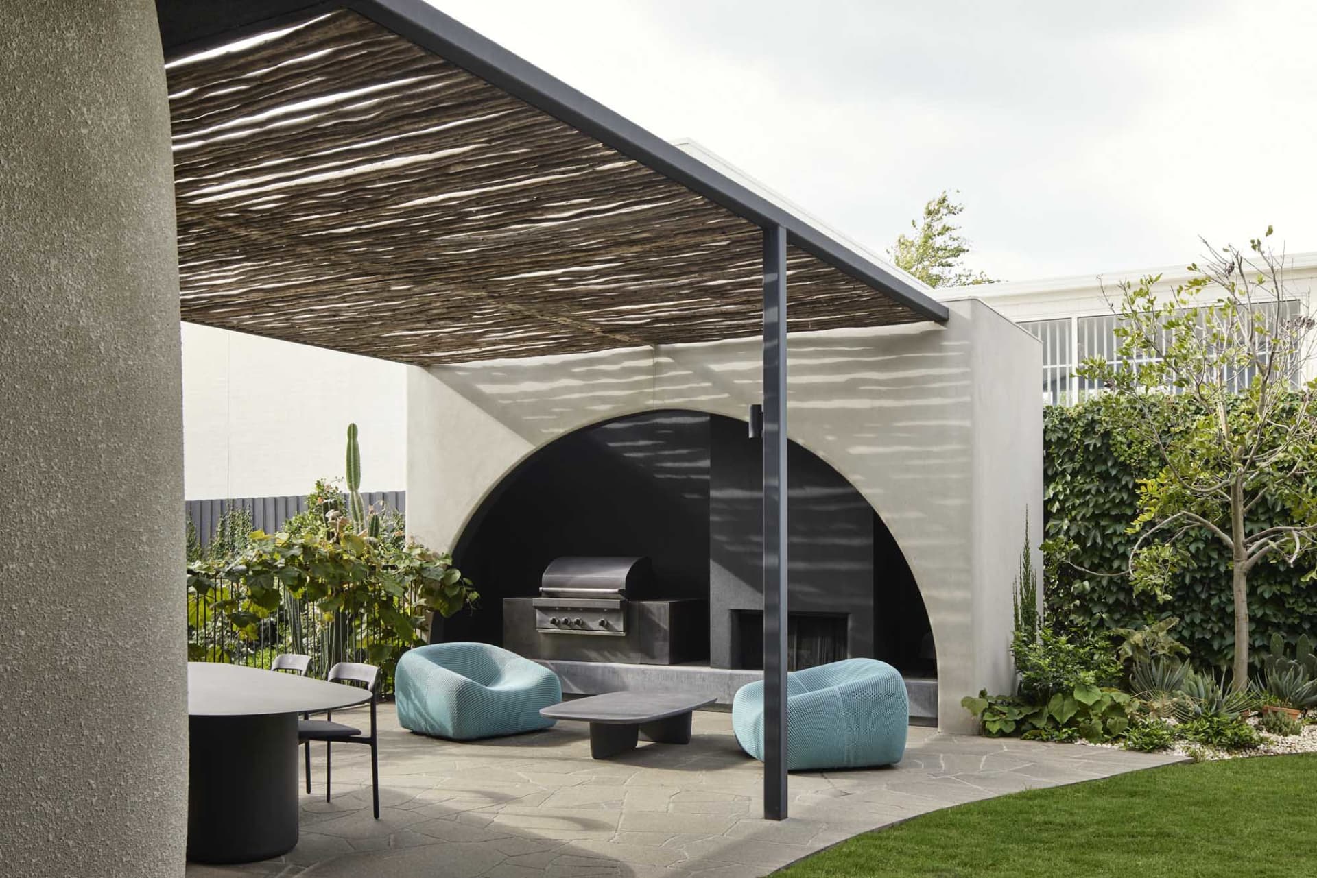 A modern outdoor space featuring concrete and metal structures, designed for relaxation and entertainment.