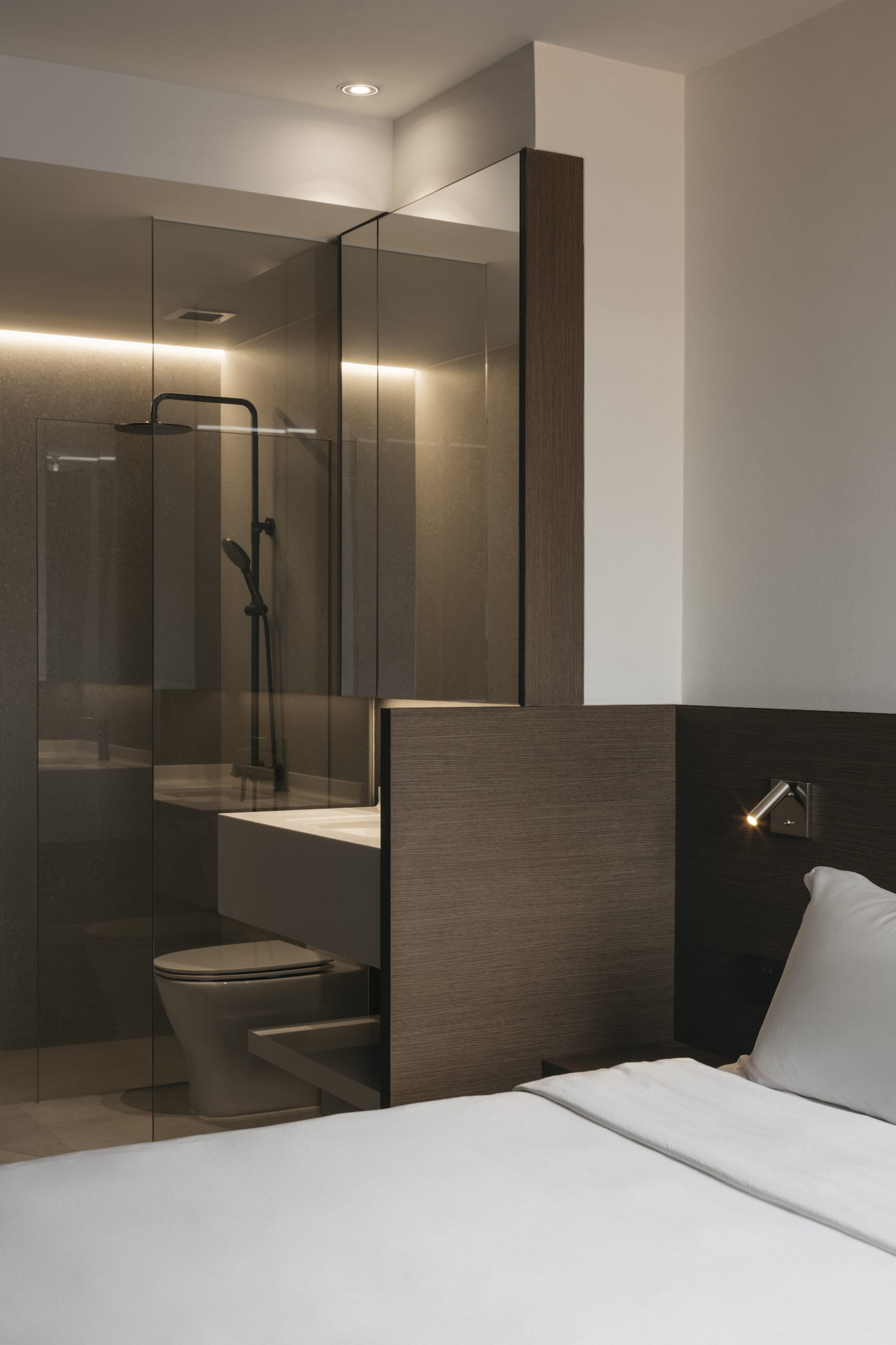 Modern minimalist bathroom featuring glass shower enclosure, wood paneling, and concrete flooring.