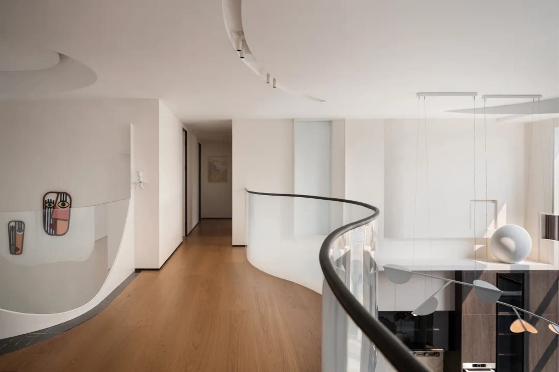 Modern minimalist residential interior with wooden floors, glass walls, and metallic accents.