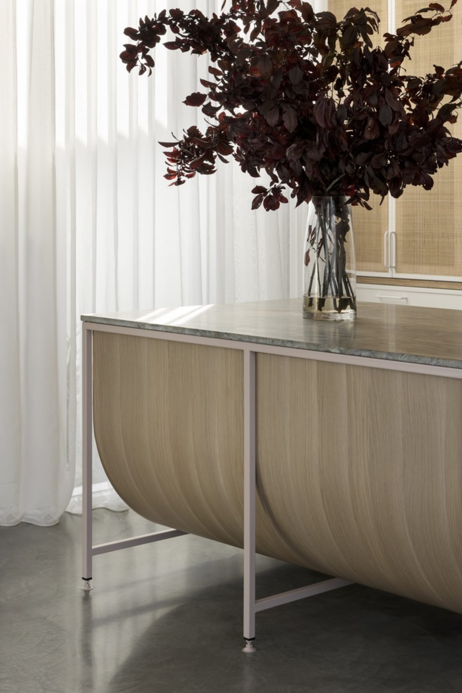 A modern, industrial-style metal desk with a marble top placed in an office setting.