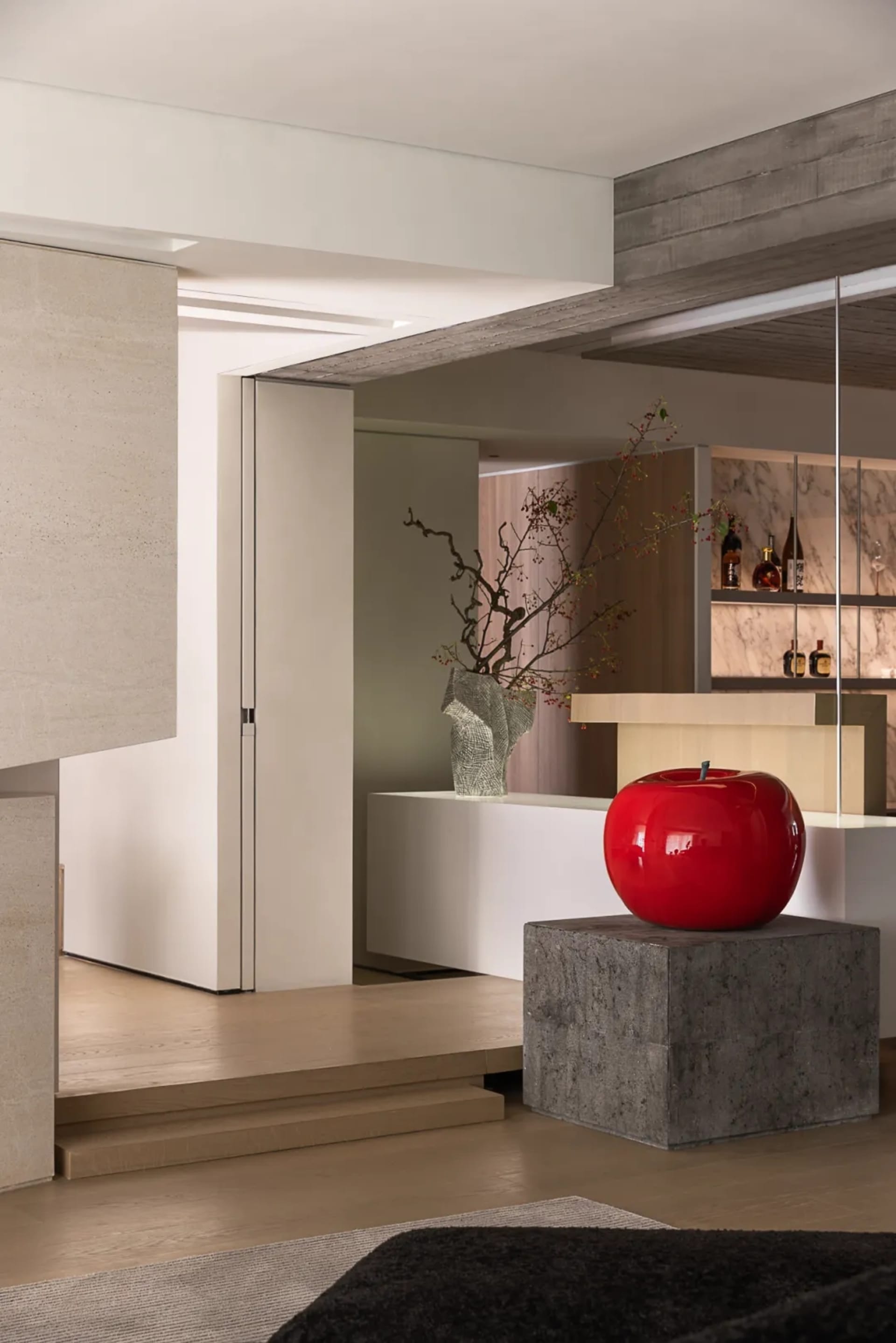 A minimalist living room featuring concrete walls and wooden furniture.