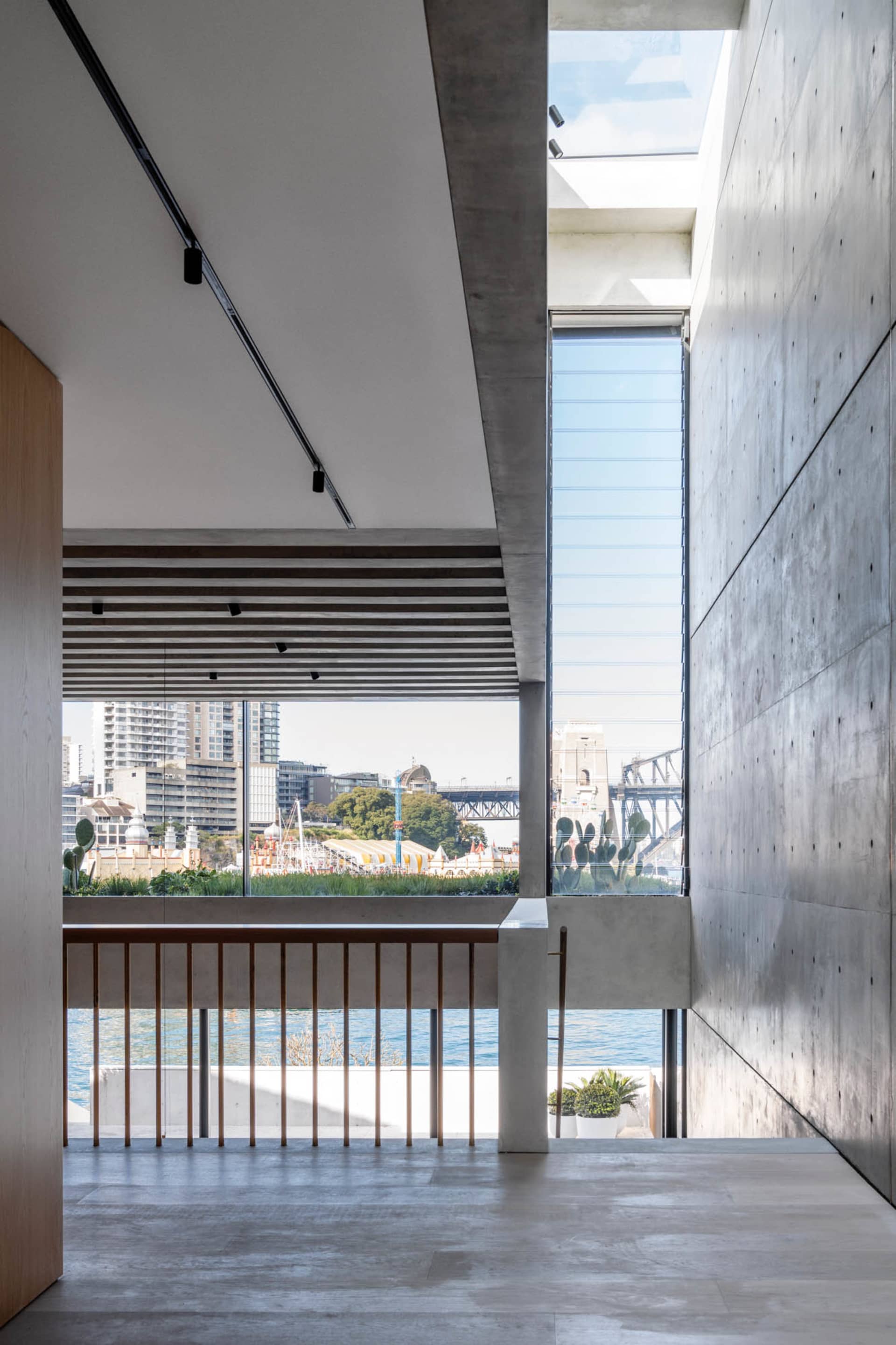 An interior design image showcasing a modern office space with concrete walls and a large window overlooking the cityscape.