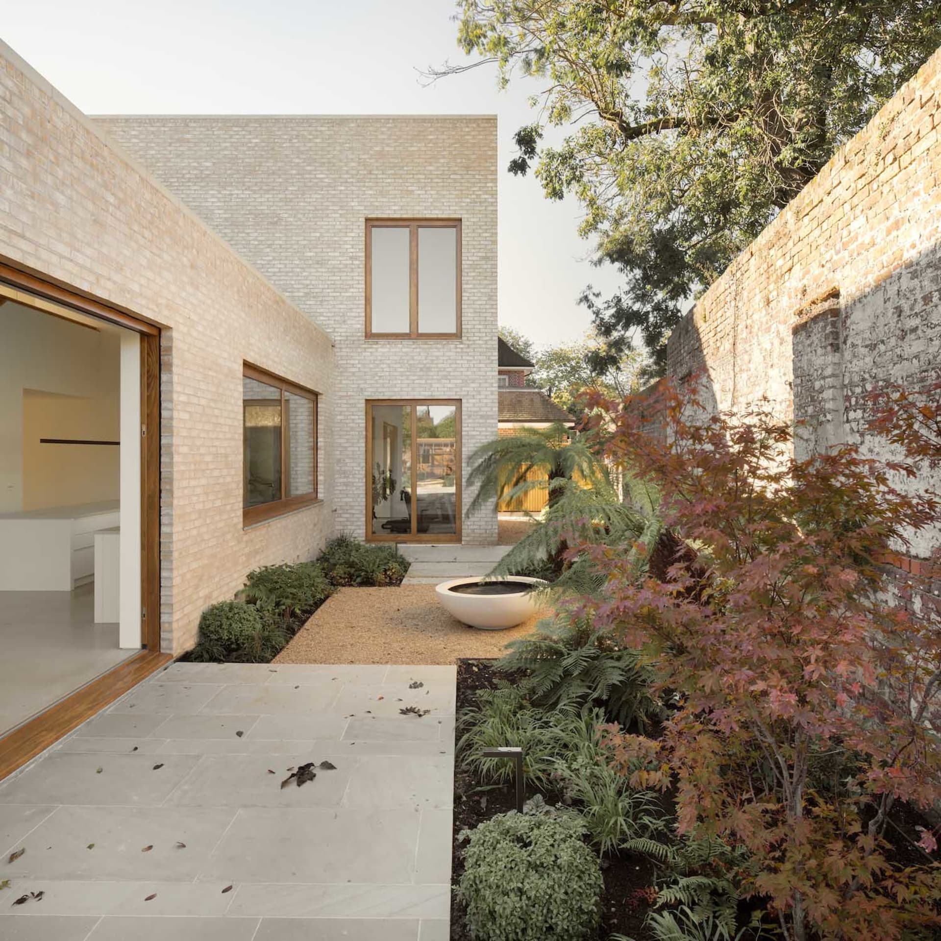 A modern house with a brick exterior, featuring large windows and a clean, minimalist design.