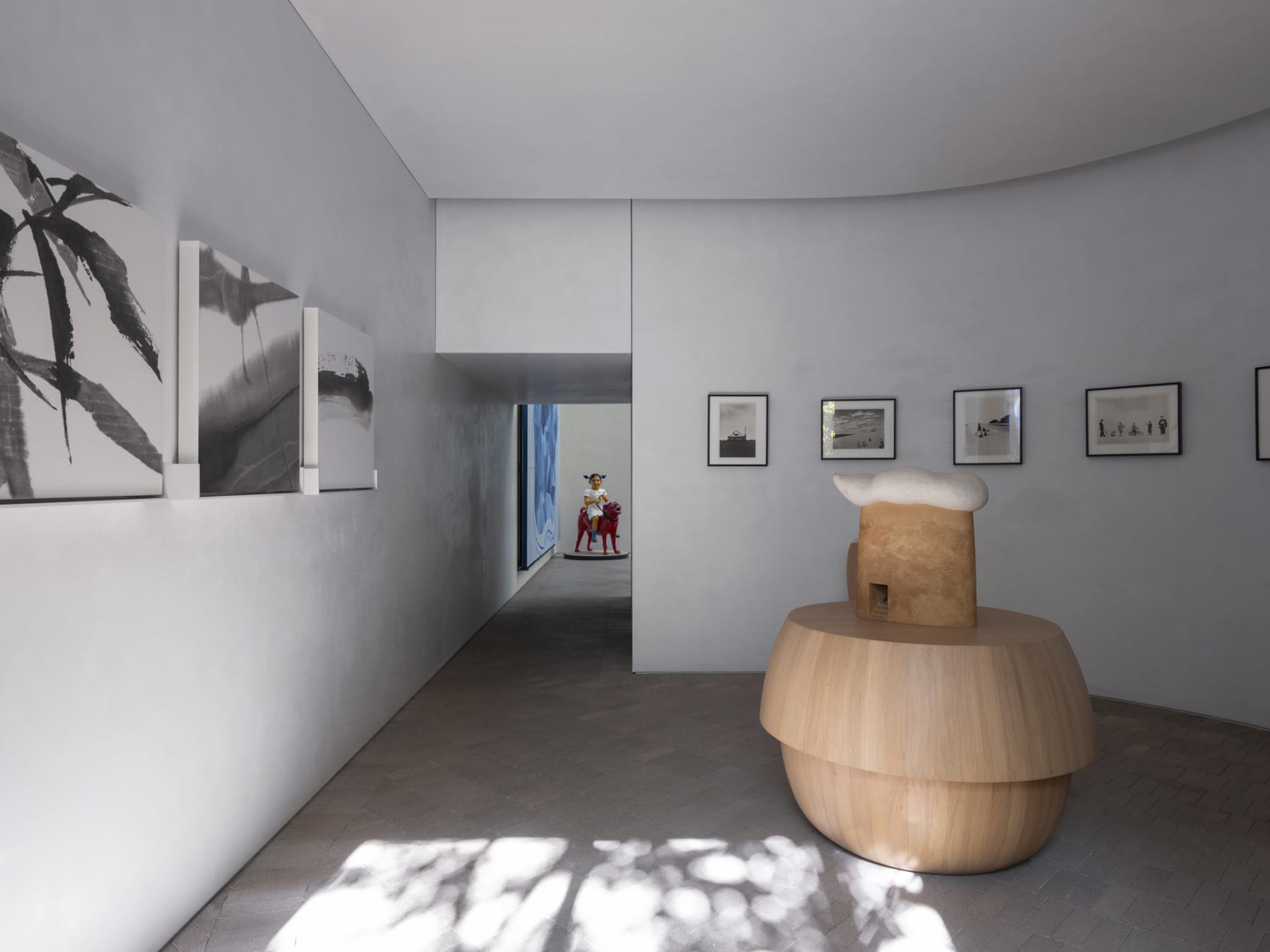極簡藝術博物館室內,展示黑白作品懸掛於淺色牆面上。