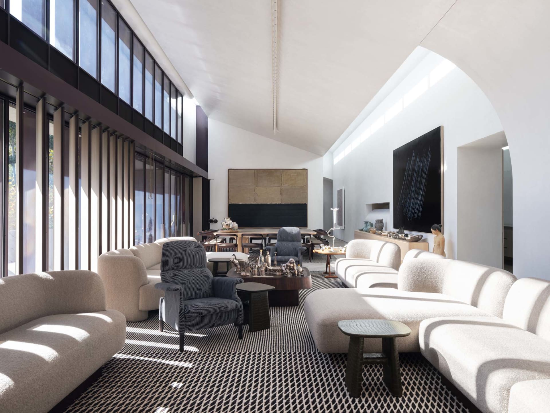Modern living room featuring upholstered furniture, concrete flooring, and minimalist decor.