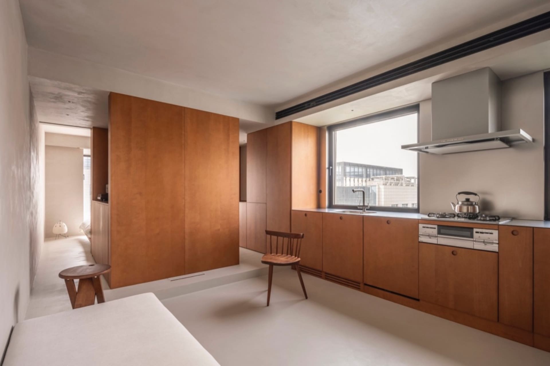A modern minimalist residential kitchen featuring wooden cabinets and white floor.