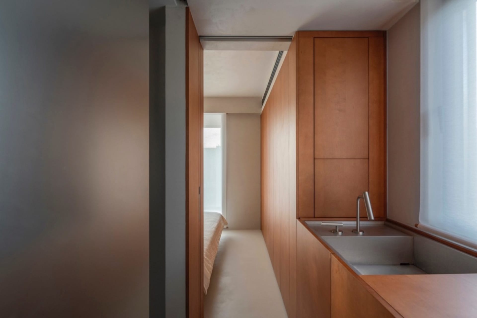 A minimalist bedroom featuring wooden paneling.