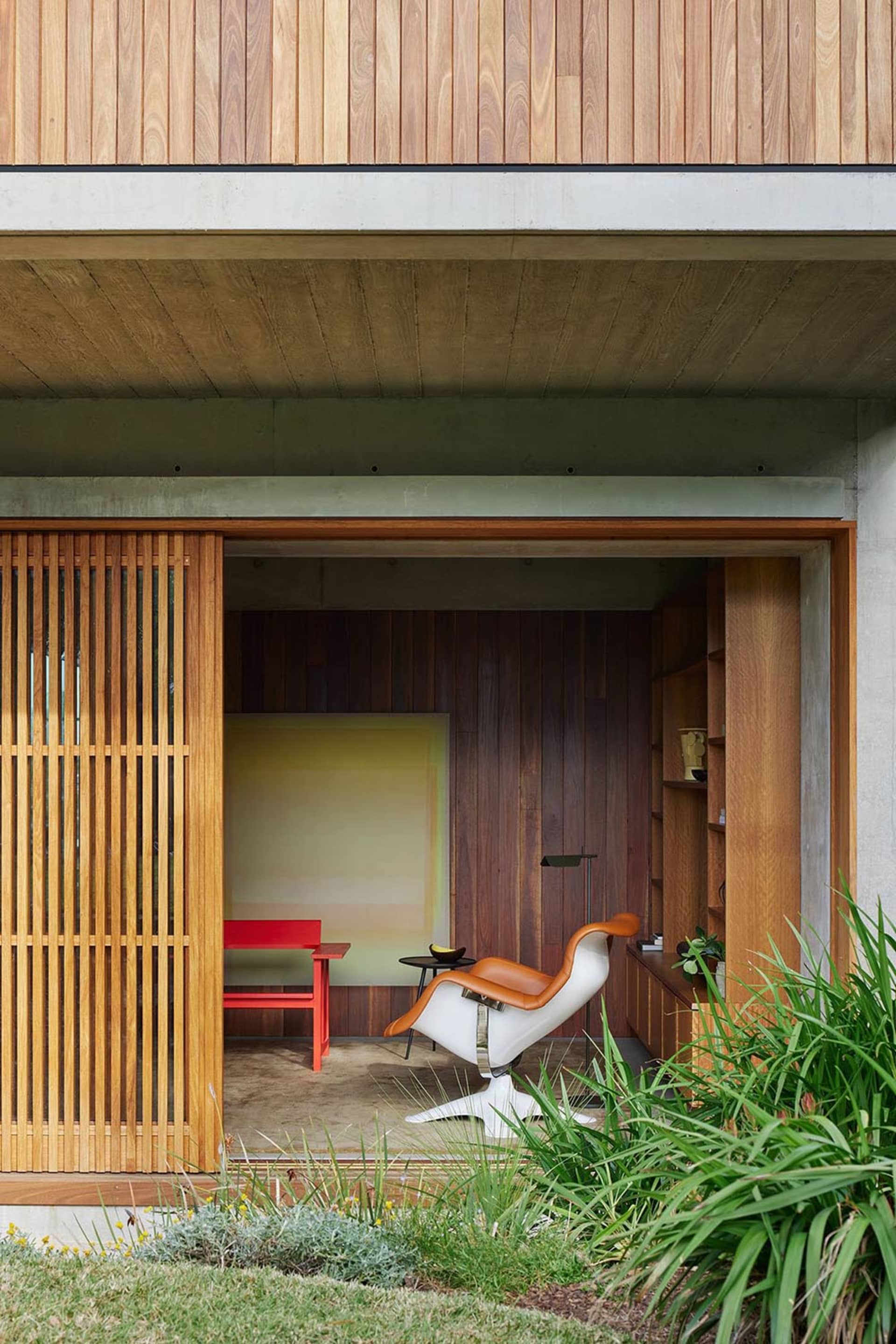 Modern minimalist living space with a slatted wood feature wall and furniture.