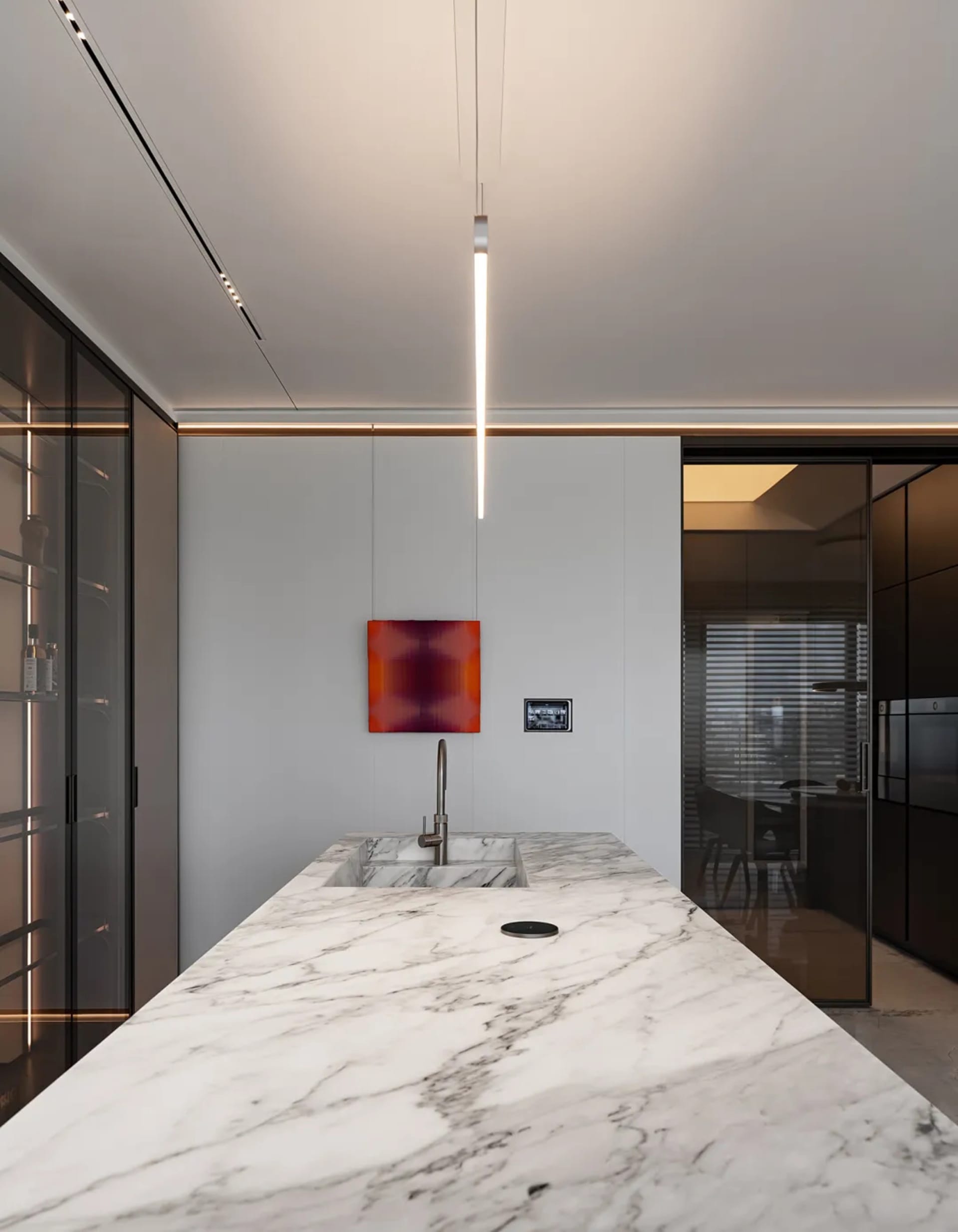 Modern minimalist residential kitchen featuring marble countertops and sleek, contemporary design elements.