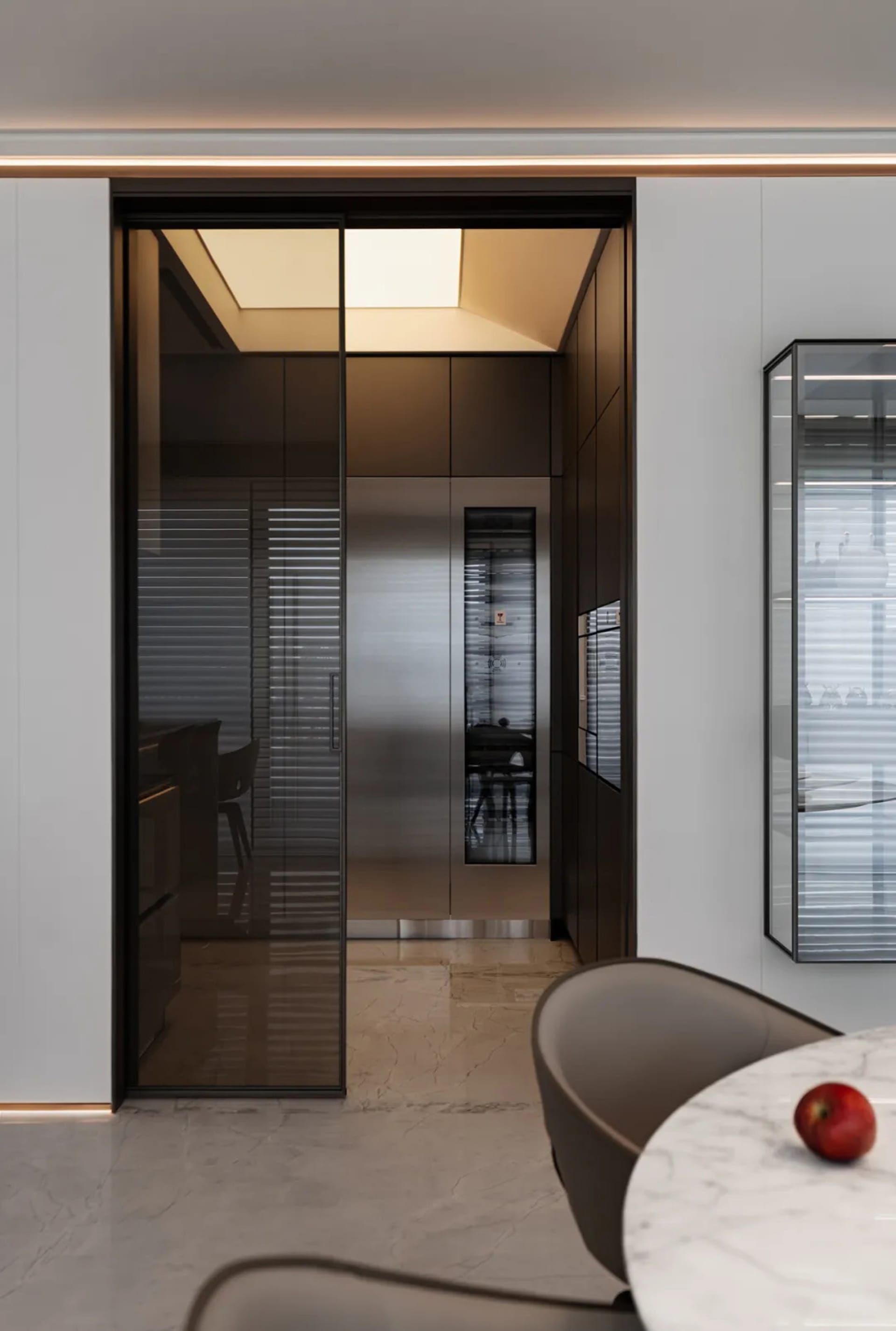 Modern kitchen featuring glass panels on a refrigerator and cabinets.