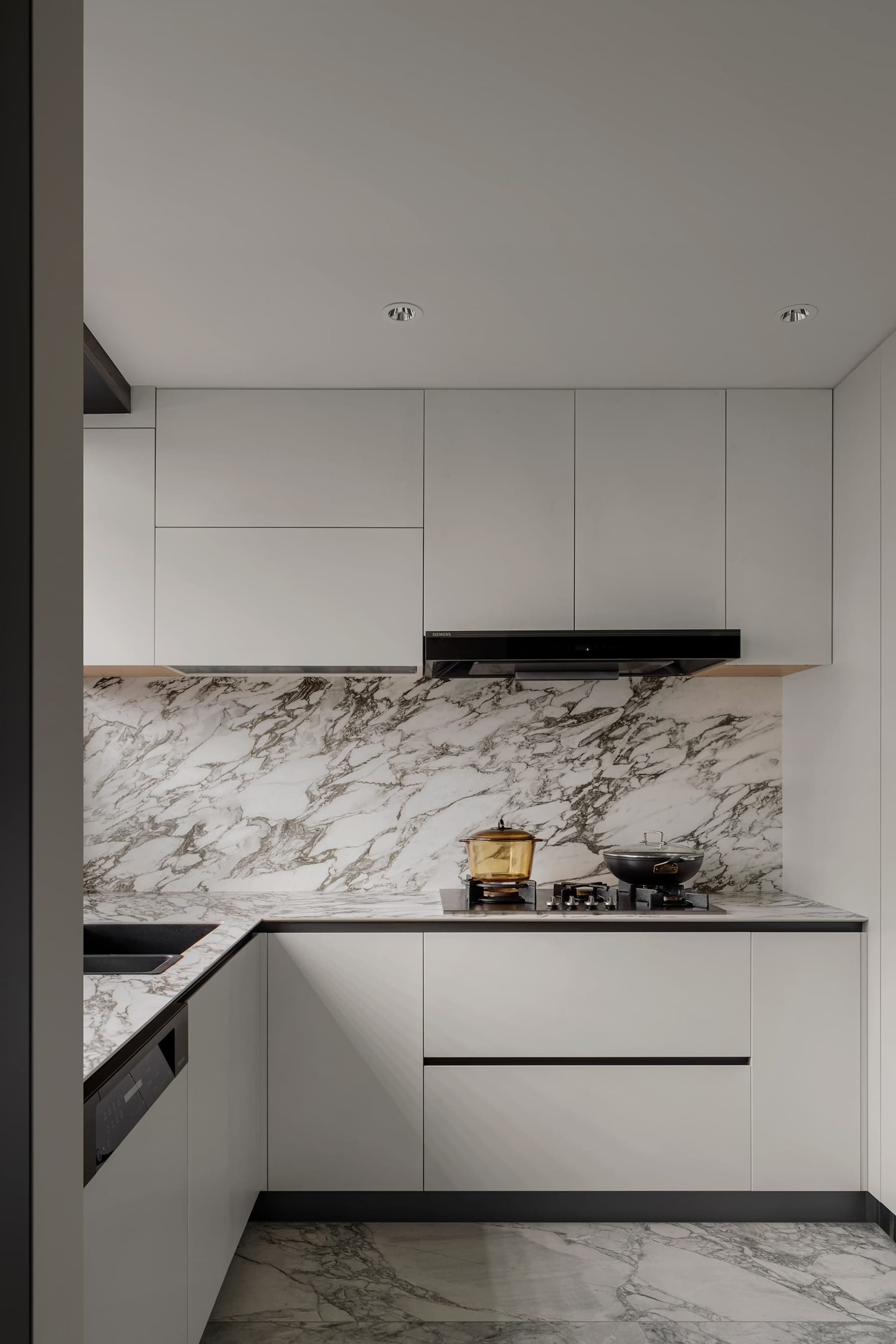 Modern minimalistic kitchen with marble countertops and floors.