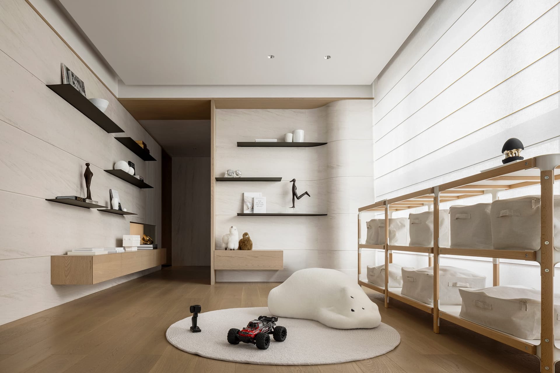 A modern playroom with a round rug, a plush cloud-shaped pillow, and a shelf with various decorative items.