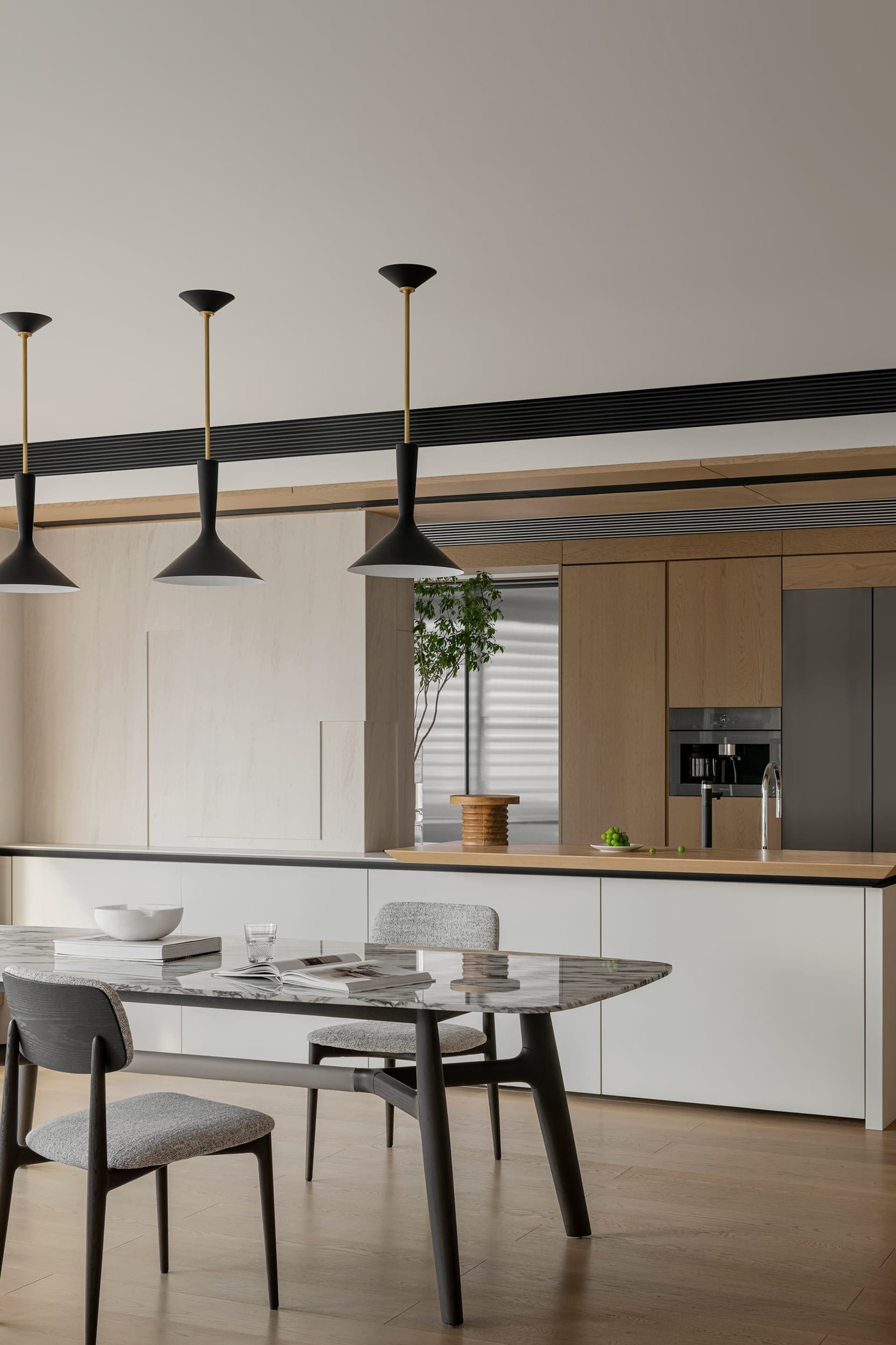 A sleek, modern kitchen featuring a marble countertop and wooden cabinetry.