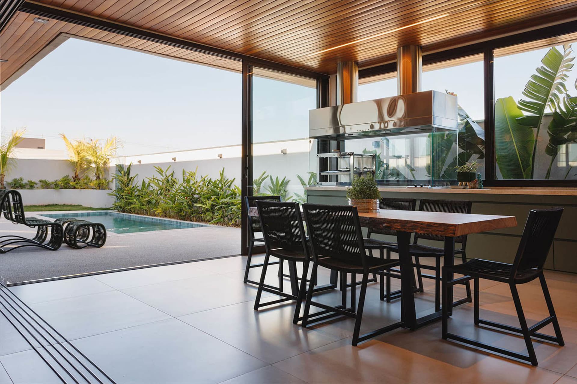 Modern residential exterior featuring industrial design elements, including glass walls and metal accents.