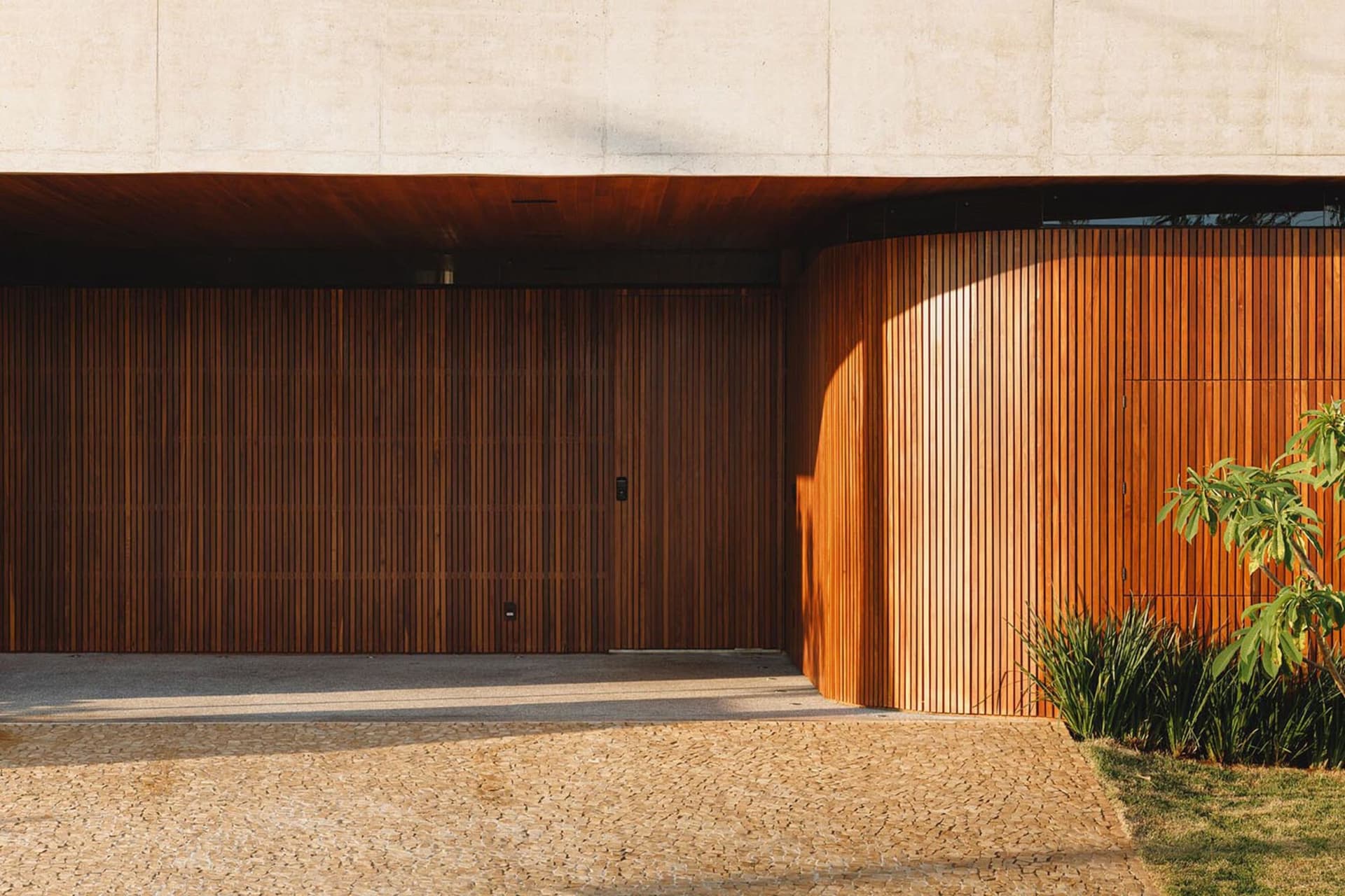 Modern exterior view of a building with wooden panels and concrete wall