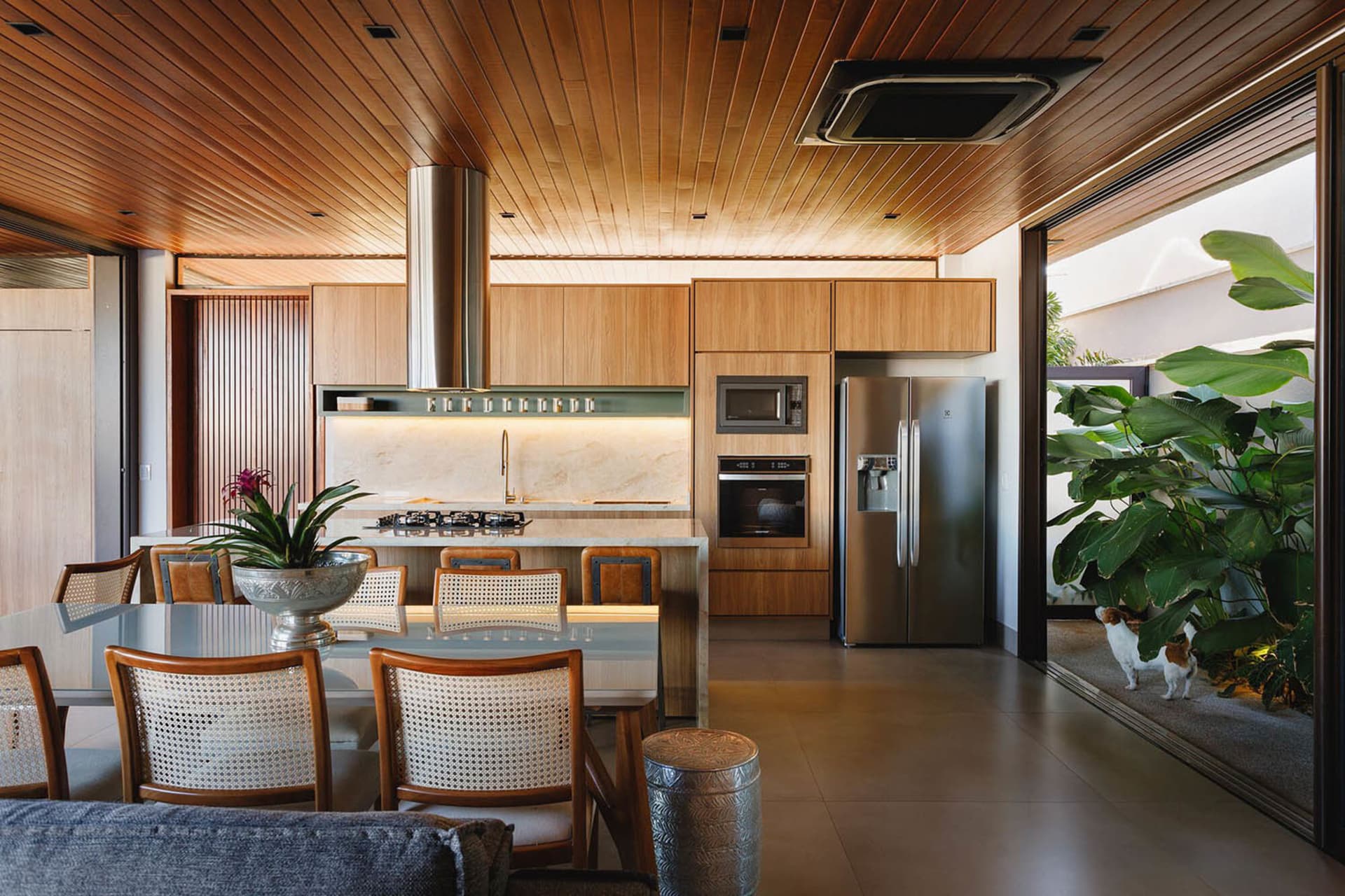 A modern kitchen with white marble countertops and wood cabinets.