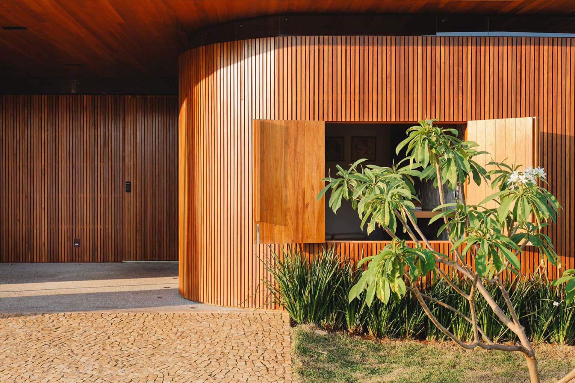 Tropical-style house with wood-paneled exterior and landscaping.