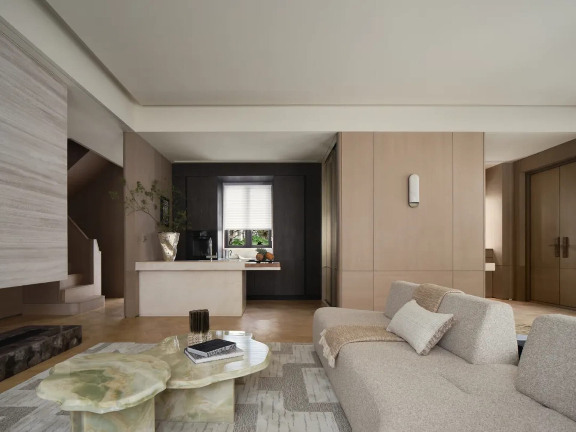 Modern minimalist living room with beige walls, wooden flooring, and a light-colored sofa.