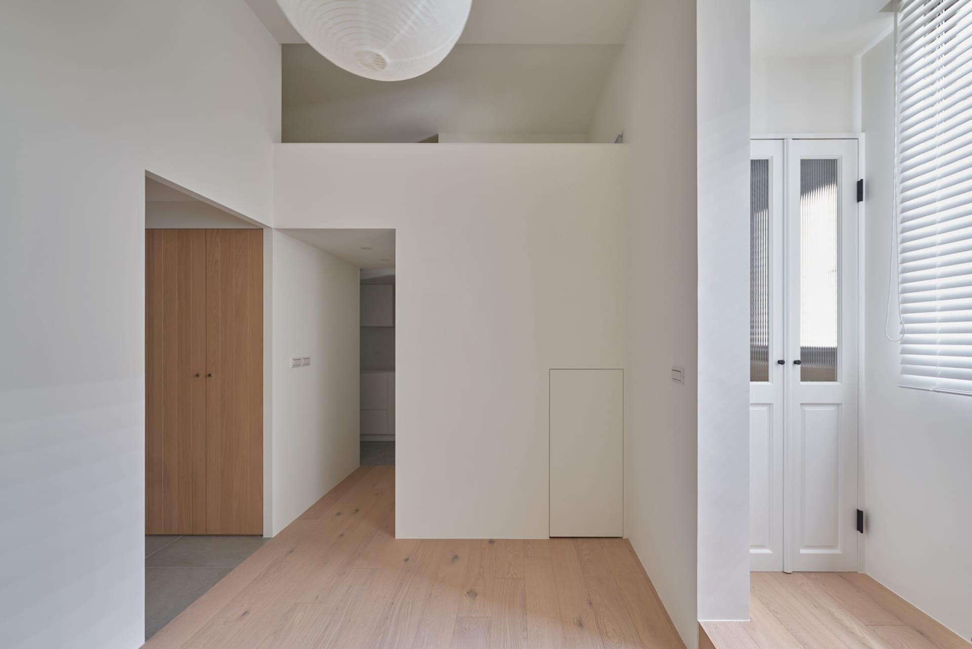 現代簡約住宅走廊,白色牆面、木地板,以及白色吸頂燈具。