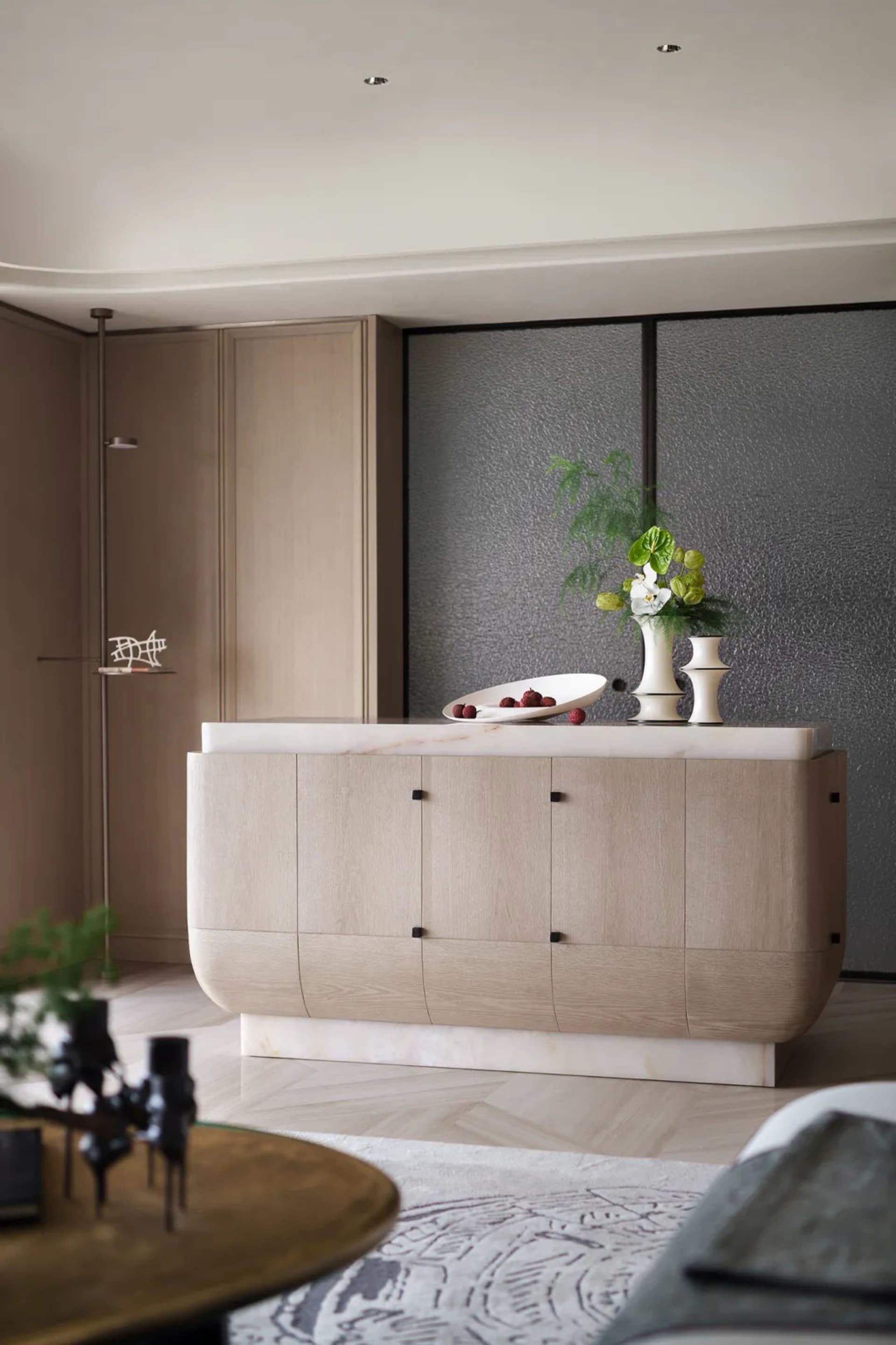 Modern living room featuring a wooden cabinet with a marble countertop, containing decorative elements like a white vase with