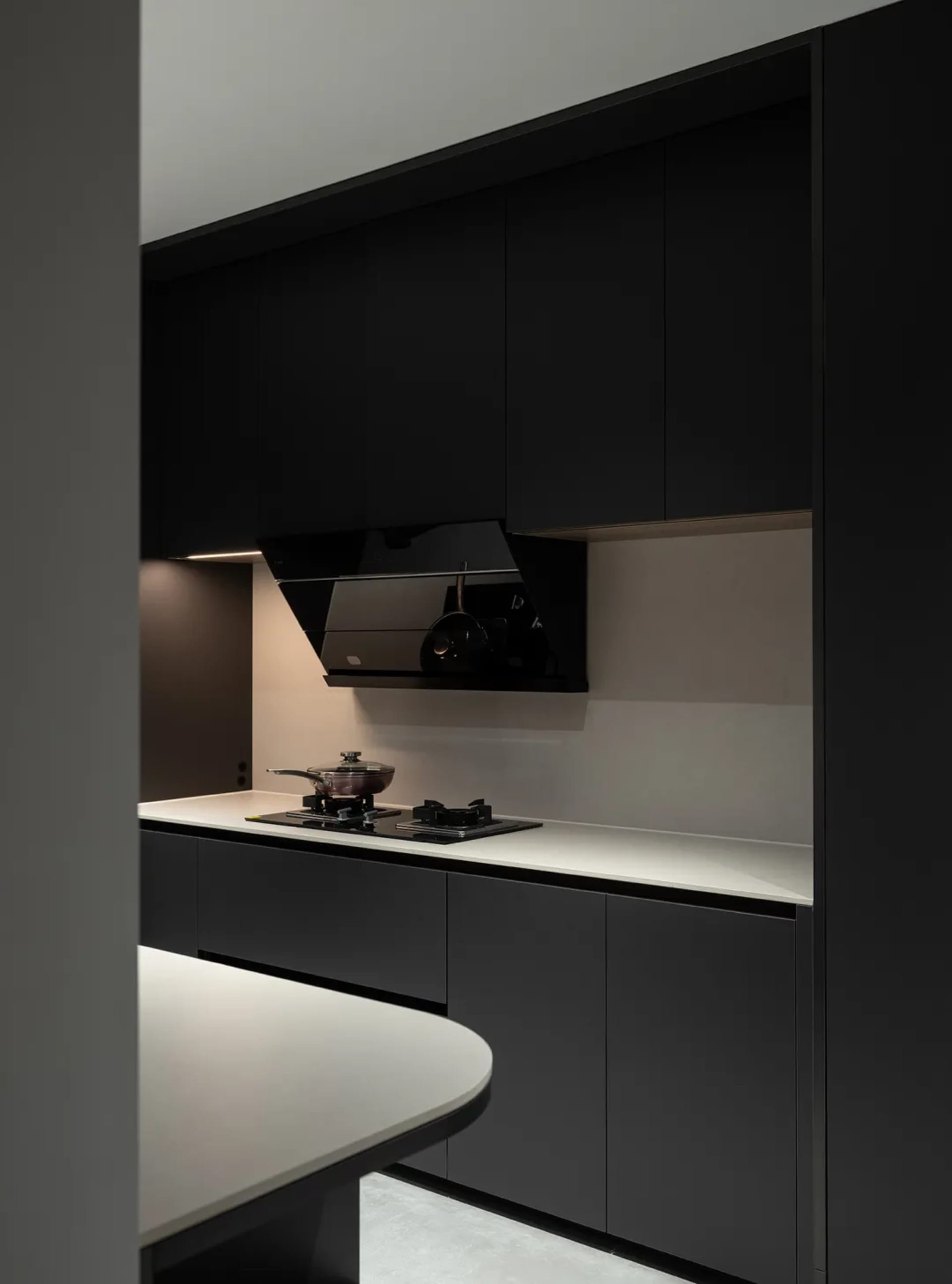 Modern minimalist kitchen with dark wood cabinets and white countertops