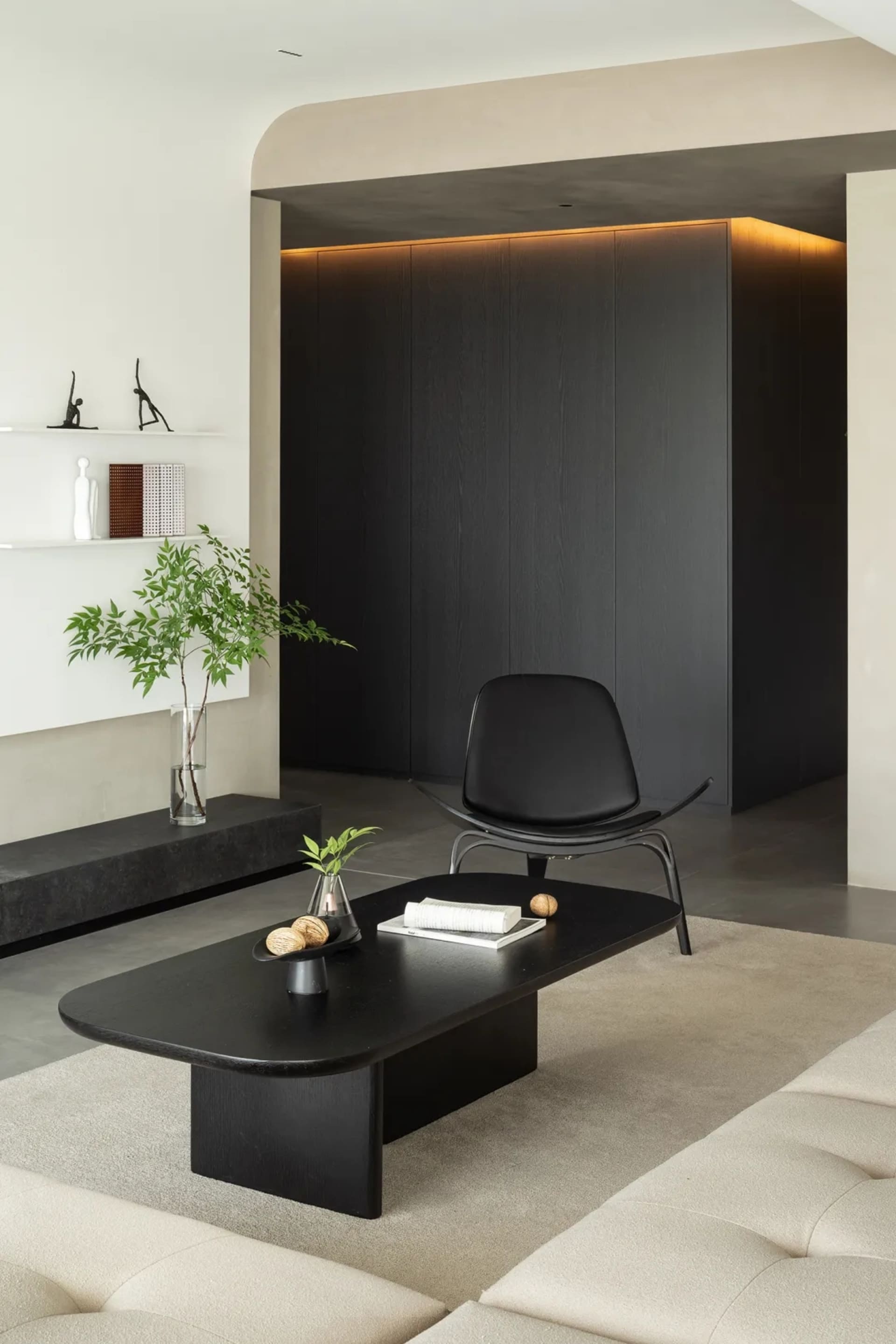 Modern living room featuring minimalist black furniture and a neutral color palette.