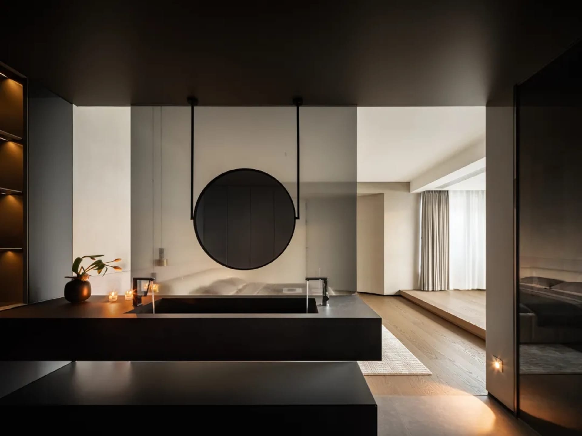 A modern minimalist bedroom with a sleek desk, wooden floor, and white décor.