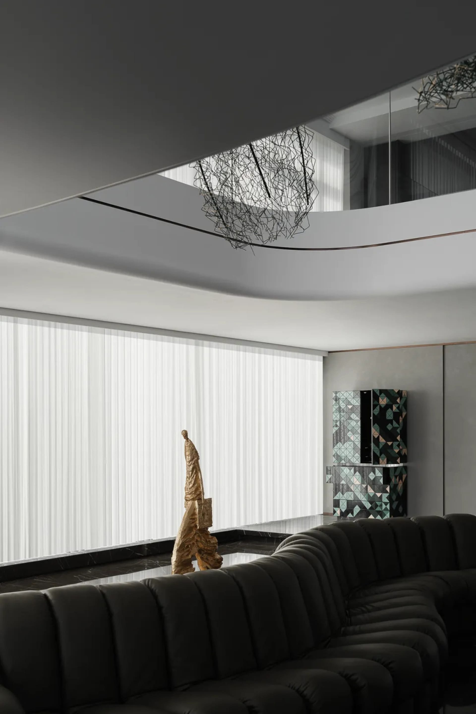 A modern living room with a glass window, leather sofa, and metal accents.